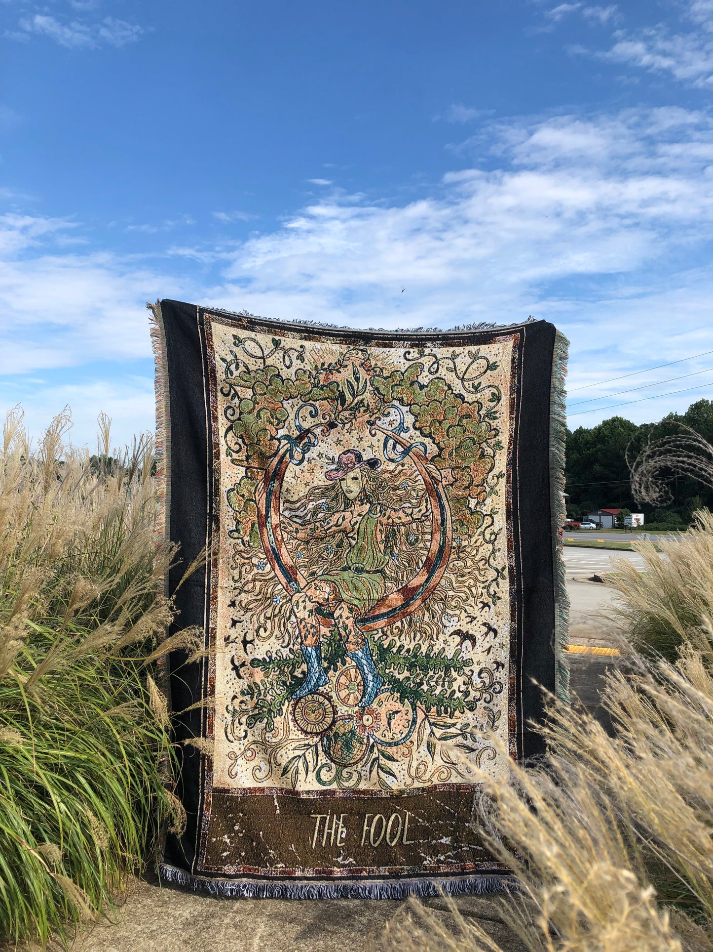 The Fool - Tarot Card Throw Blanket/ Woven Tapestry holding up on a field