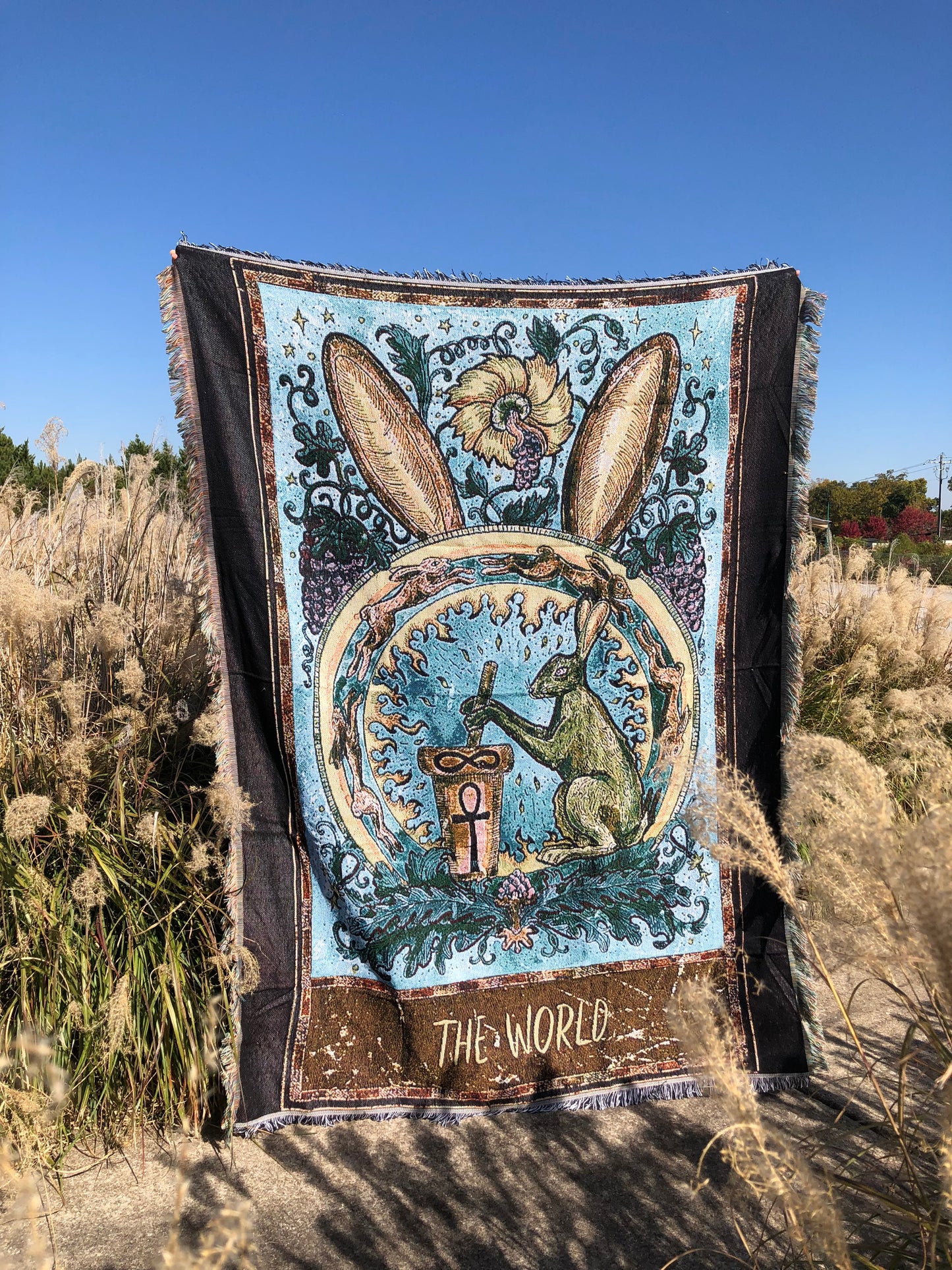 The World - Tarot Card Throw Blanket/ Woven Tapestry holding up in the middle of the field