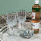 A close up shot of the South Sea White Mother of Pearl Tray on a khaki blanket, with glasses, a bottle, and a glass swan