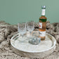 South Sea White Mother of Pearl Tray on a khaki blanket, with glasses, a bottle and a glass swan