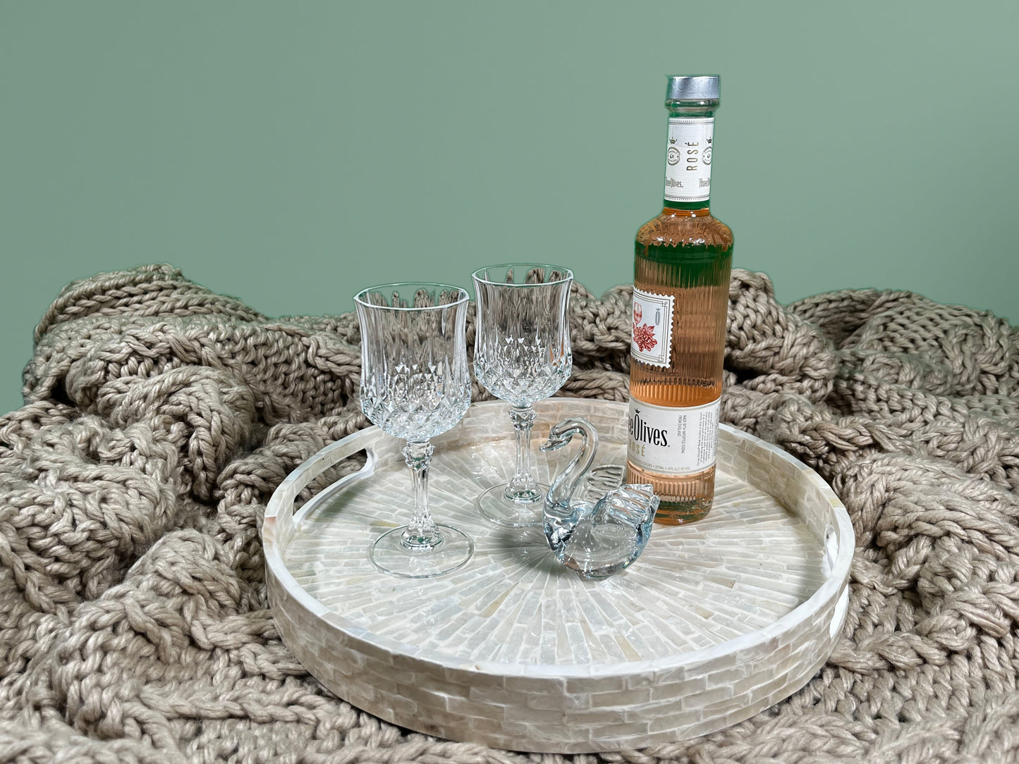 South Sea White Mother of Pearl Tray on a khaki blanket, with glasses, a bottle and a glass swan