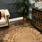 Circle Seagrass Rug next to a drawer, a plant and the sofa