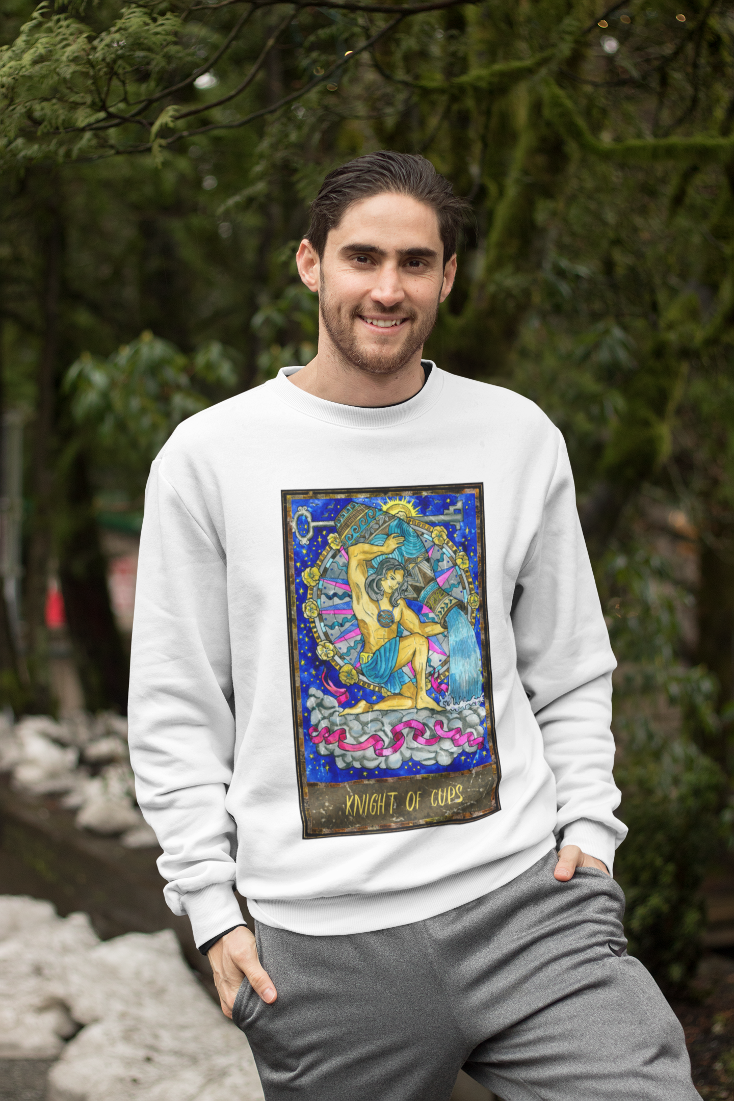 A man wearing a white Knight of Cups Tarot Card Sweatshirt and grey pants