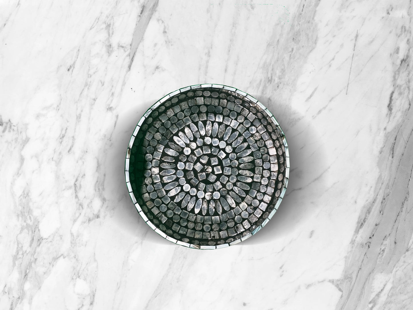 A top down shot of Curvy Round Mother of Pearl Tray on a marble surface