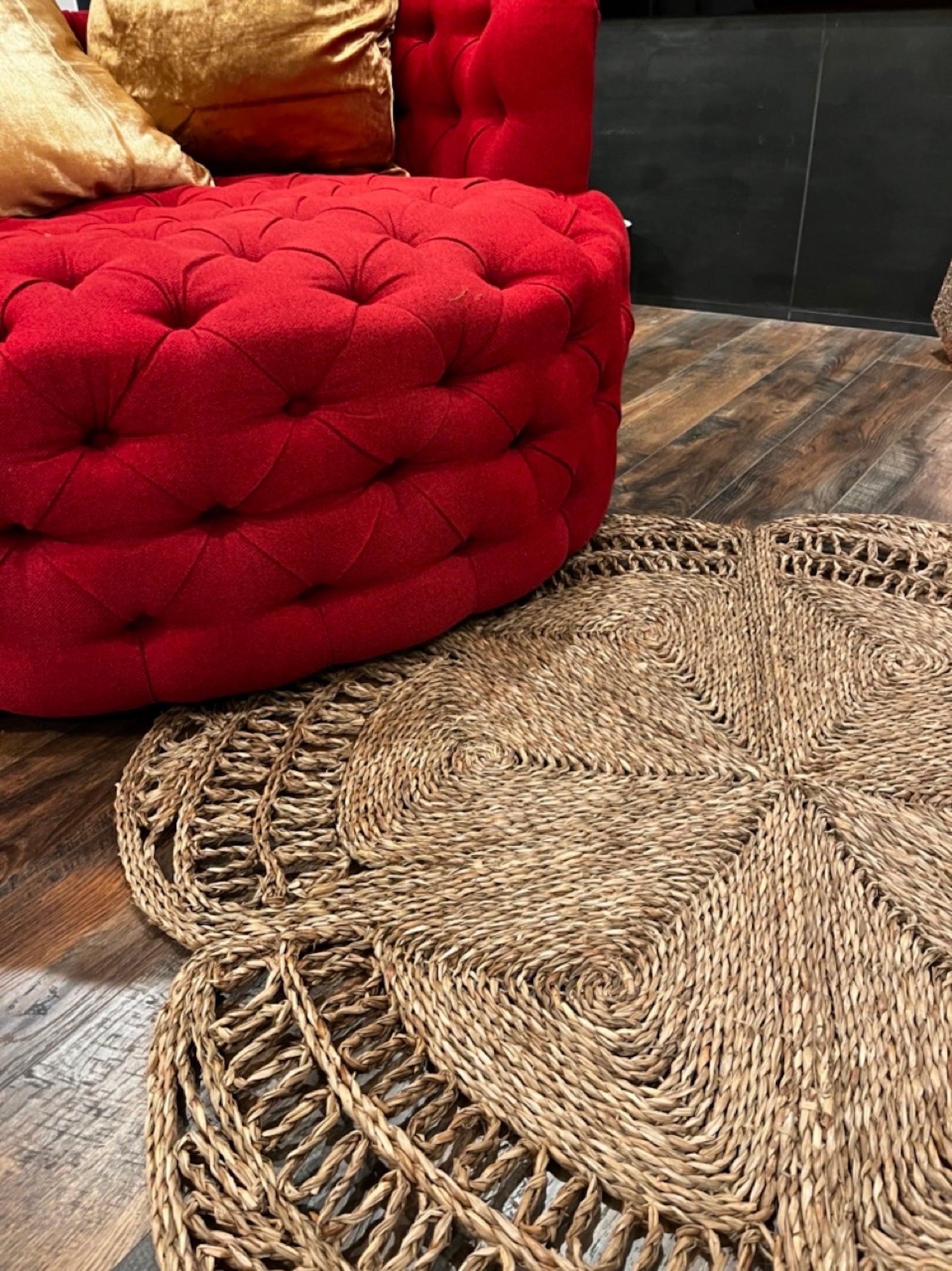 semi close up shot of the Flower Seagrass Rug next to a red chair