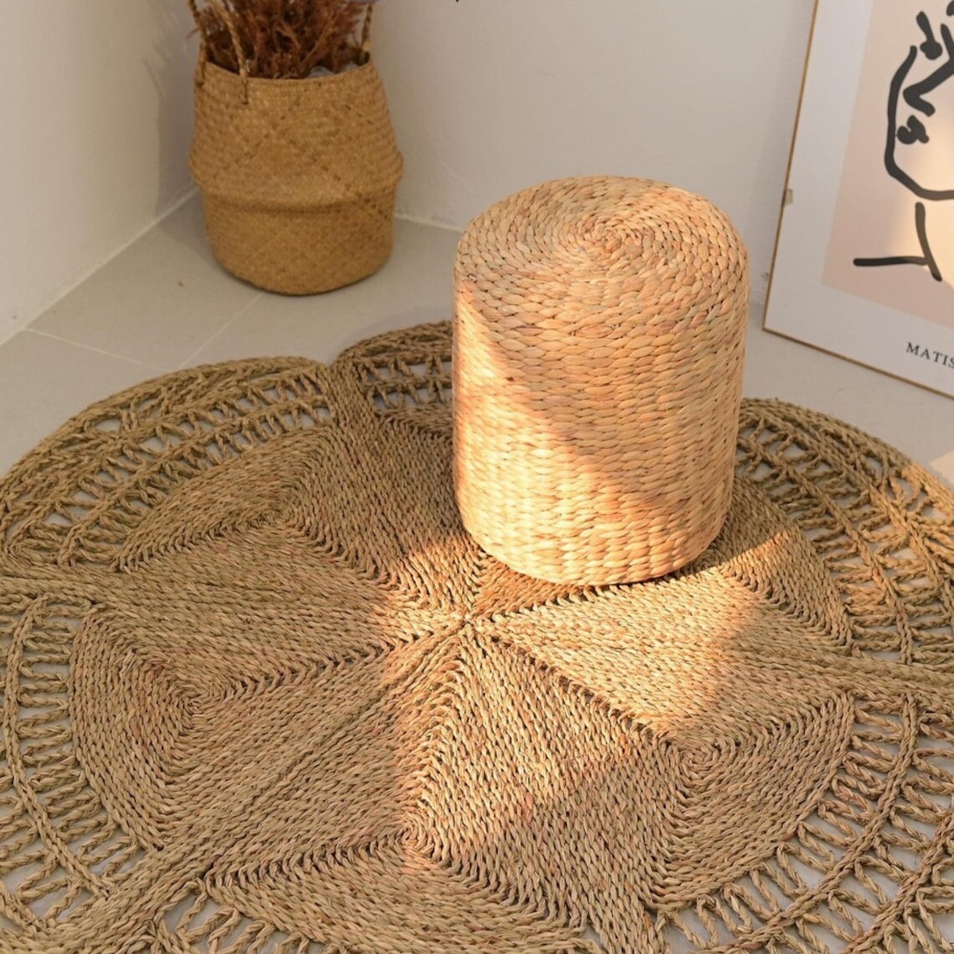 Flower Seagrass Rug in the corner of a room with baskets and a picture