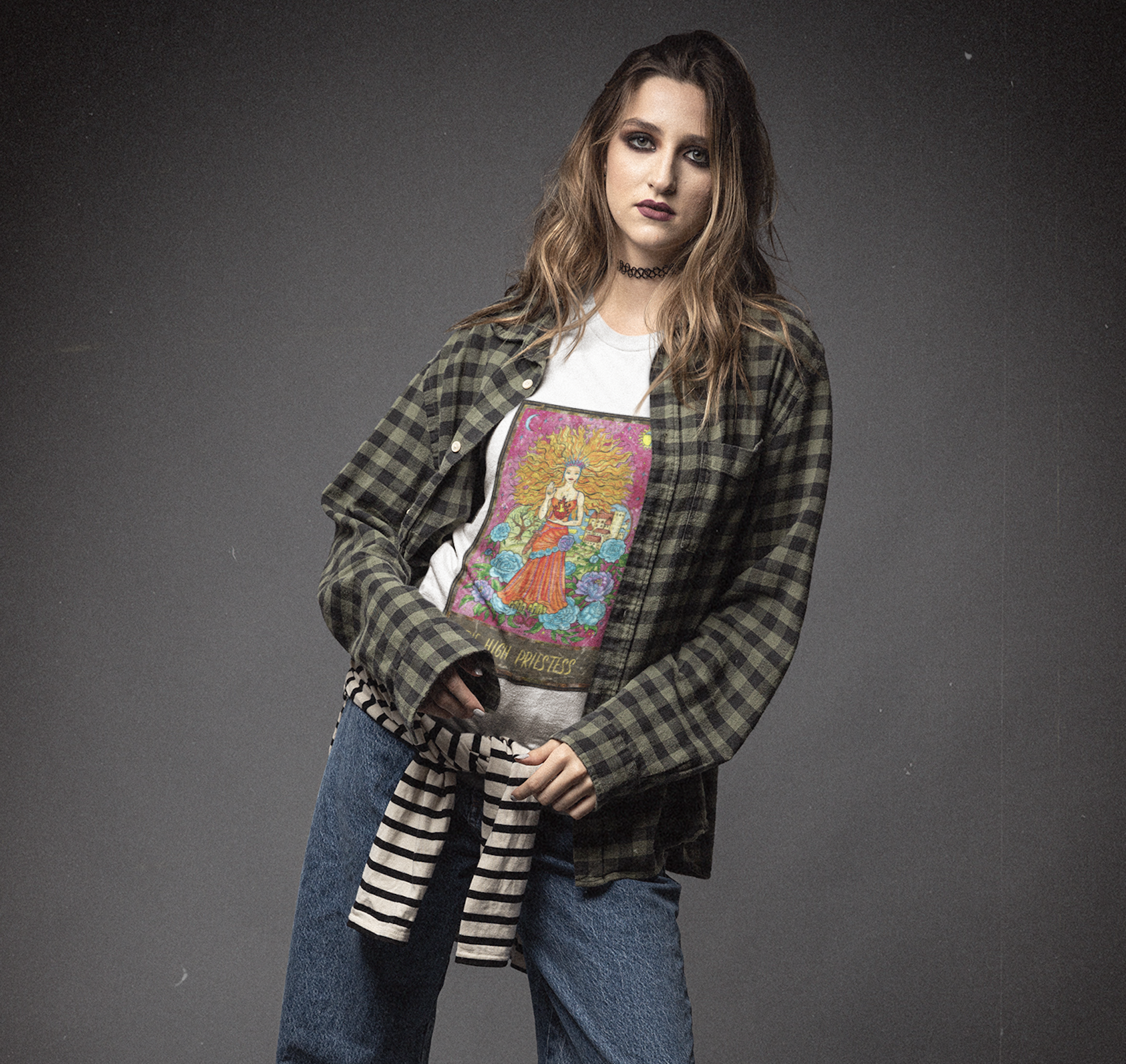 A woman wearing a white The High Priestess Tarot Card T-shirt inside a shirt and blue jeans