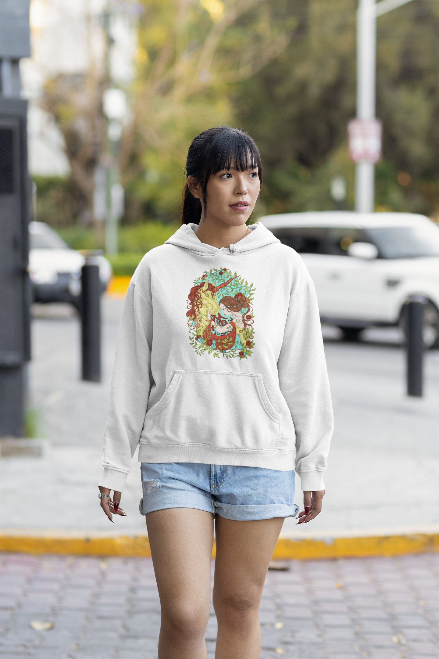 A young woman wearing a white Russet Princess and Magic Unicorn Hoodie and shorts