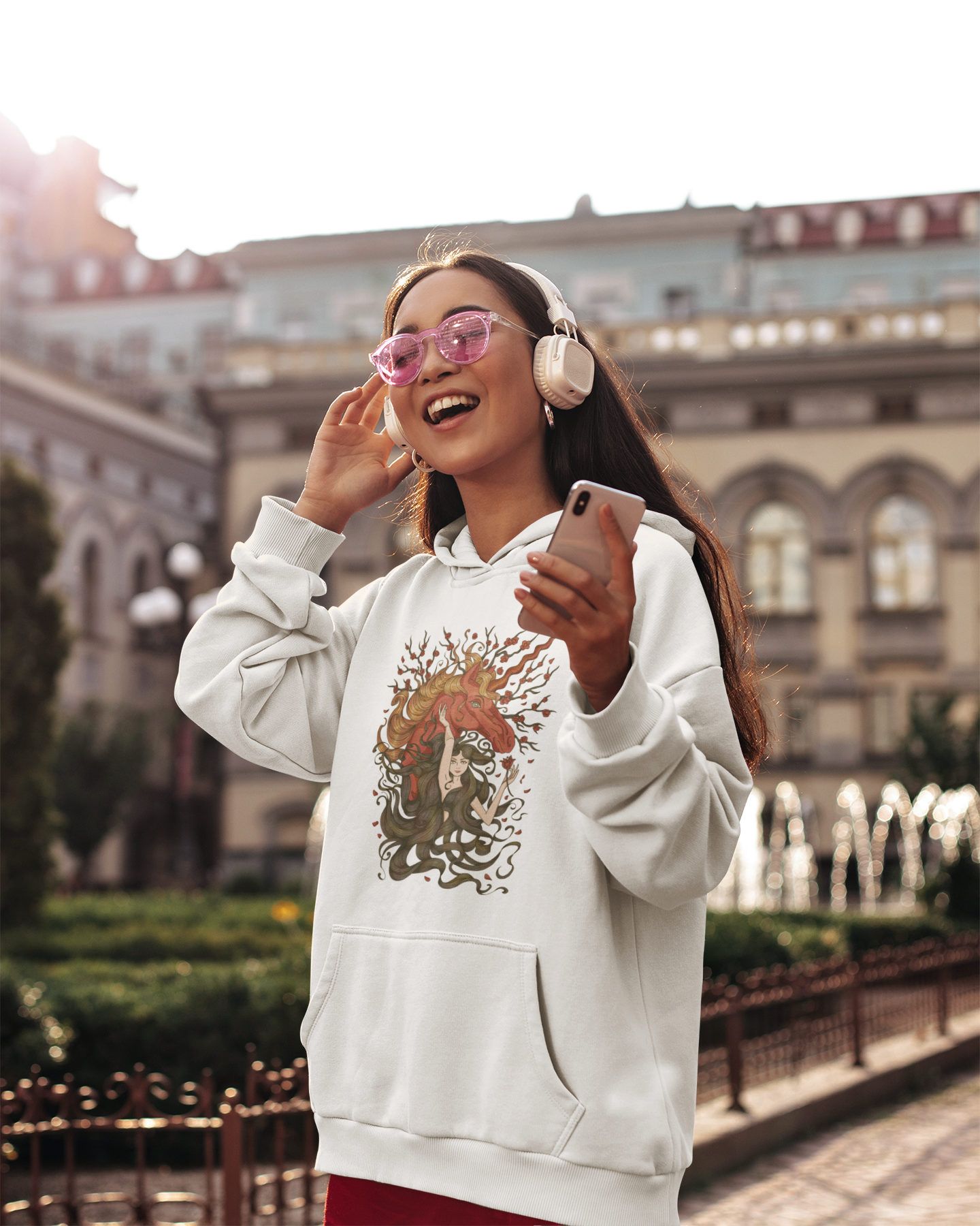 A woman with sunglasses listening to music wearing a white Walnut Brown Princess and Magic Unicorn Hoodie and red skirt