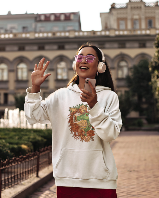 A woman with pink sunglasses and headphones, holding her phone and wearing  a white Cocoa Brown Princess and Magic Unicorn Hoodie and a red skirt