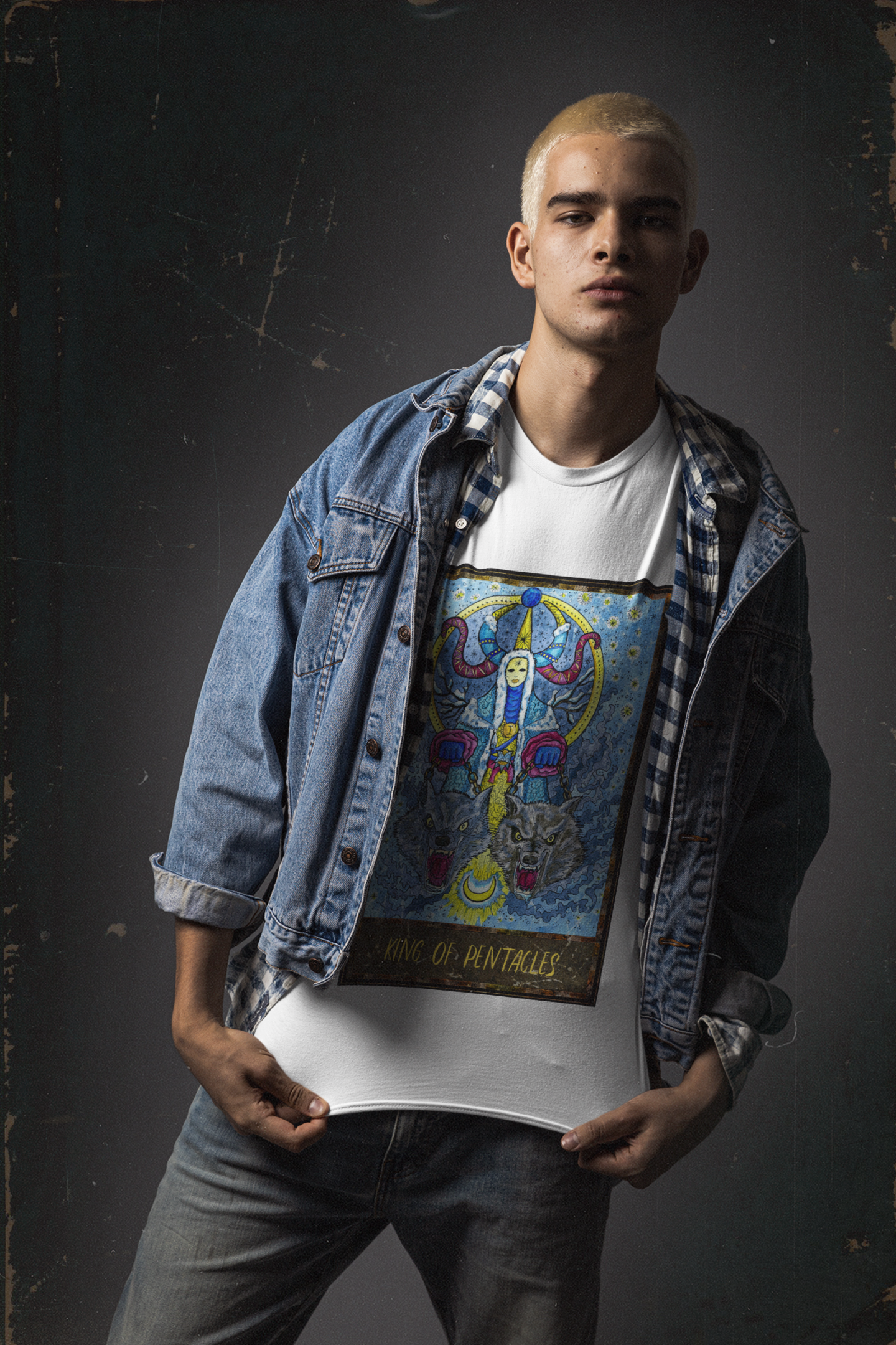 A man showcasing his white King of Pentacles Tarot Card T-Shirt, wearing a checkered collar shirt, a blue denim jacket, and fade blue jeans