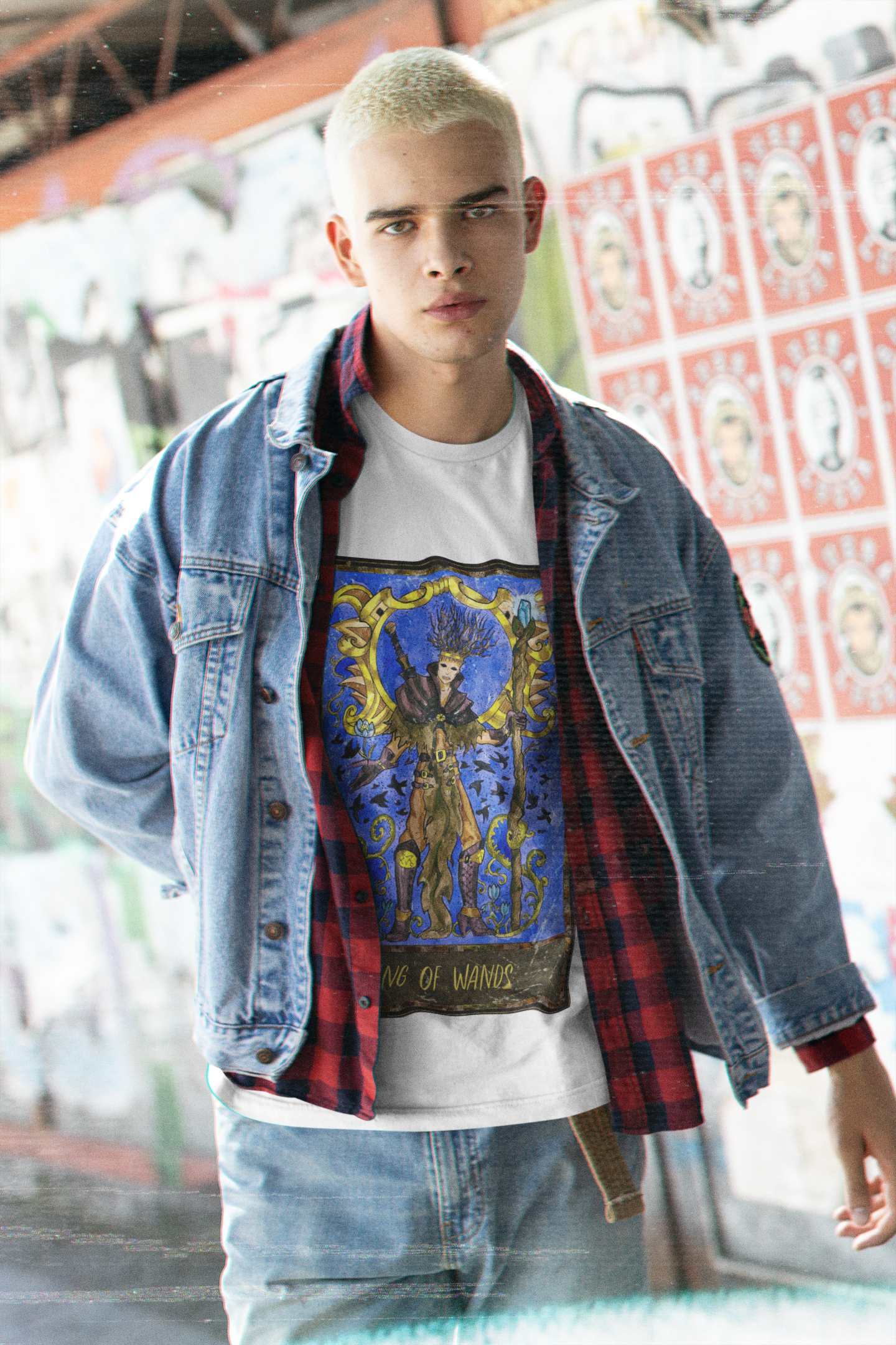 A man wearing a white King of Wands Tarot Card T-Shirt inside a black and red checkered shirt, a blue denim jacket, and blue jeans