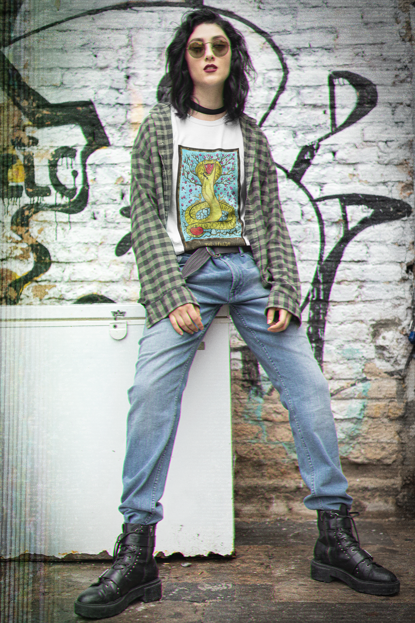 A woman wearing a white The Lovers Tarot Card T-Shirt inside a check pattern collar shirt, blue jeans, and black boots