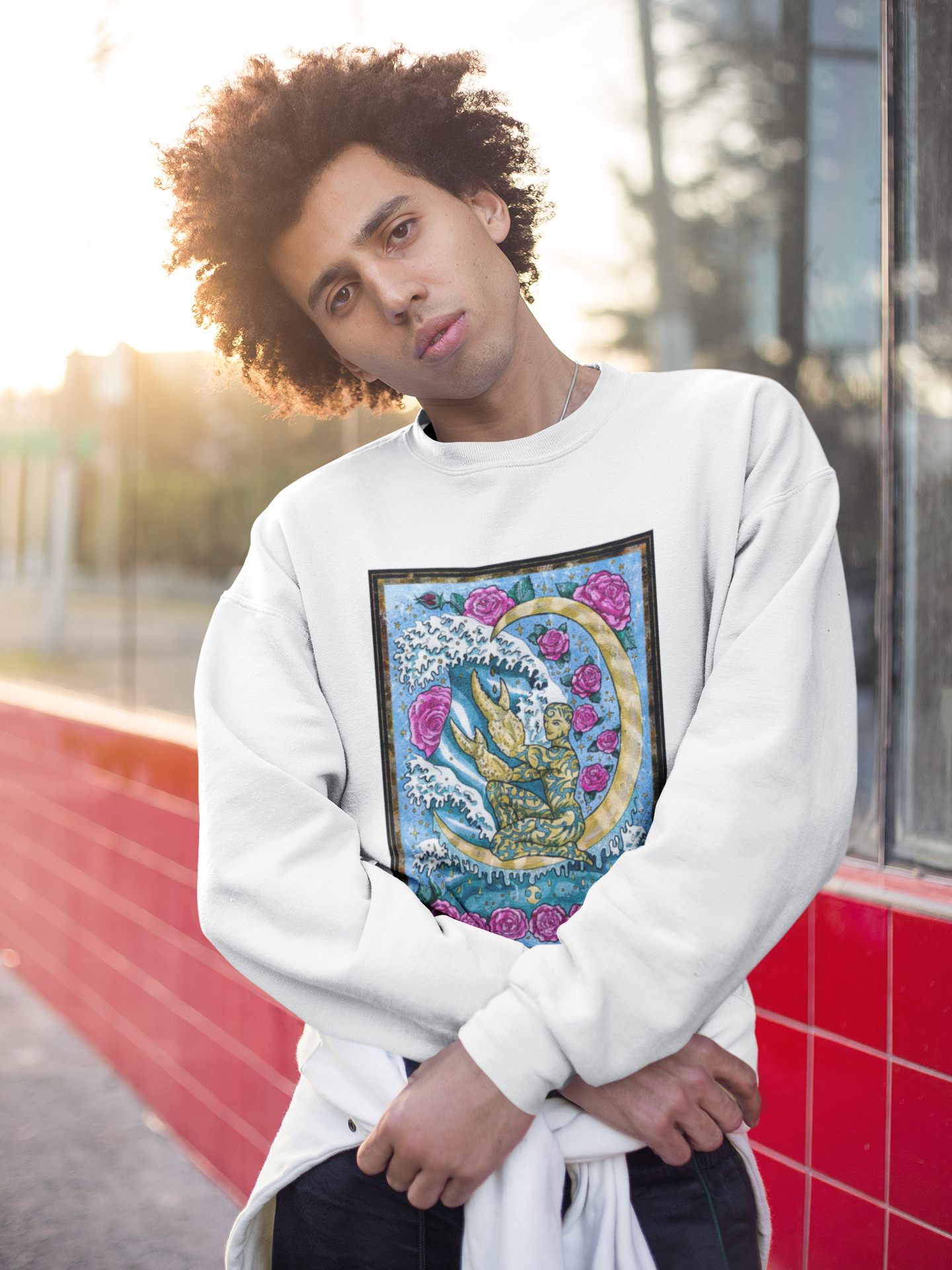 A man wearing a white The Moon Tarot Card Sweatshirt and posing in front of a store window