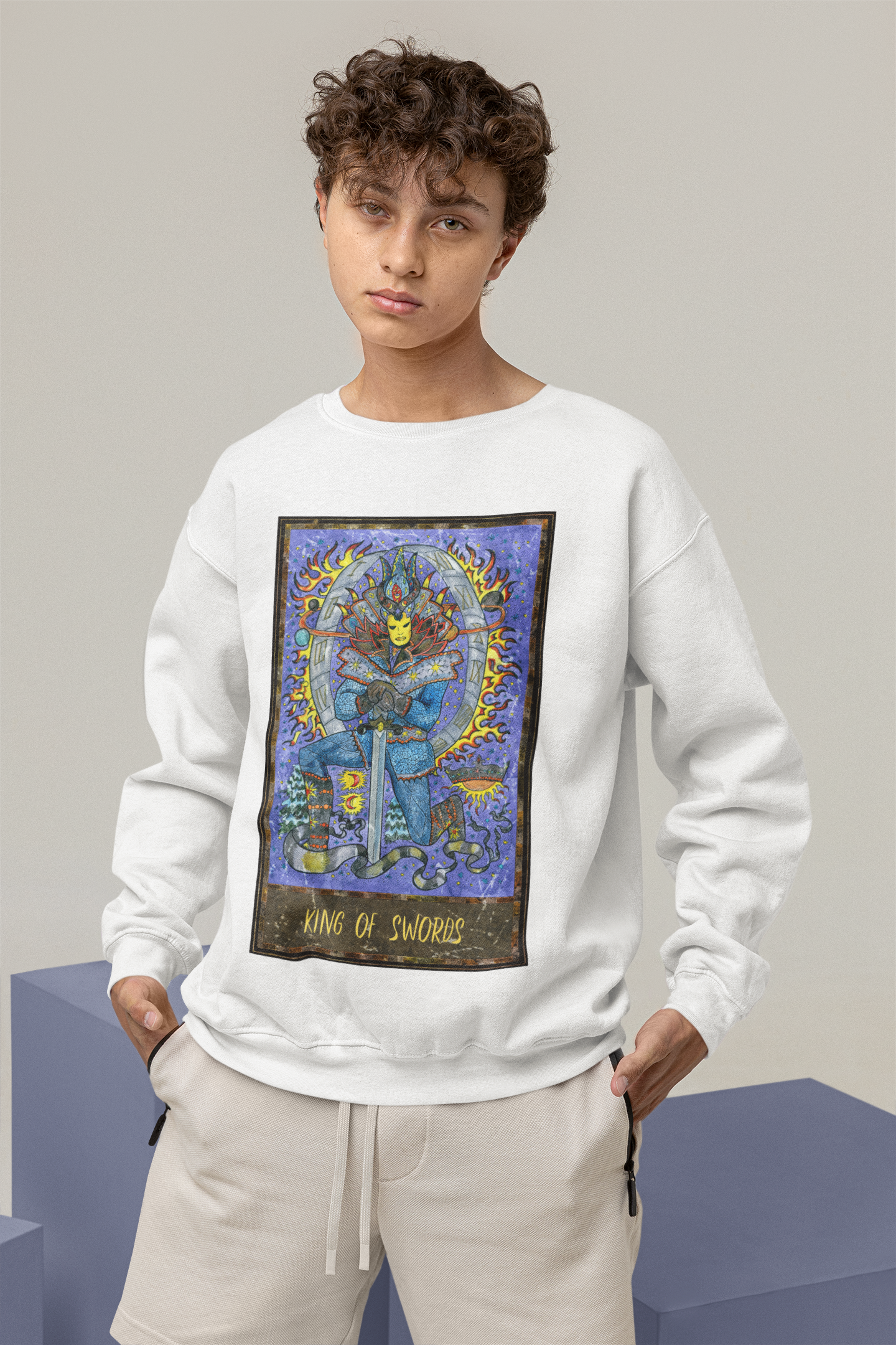 A man wearing a white King of Swords Tarot Card Sweatshirt, beige pants