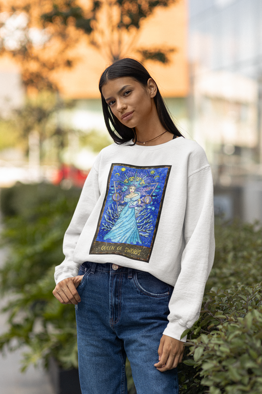 A woman wearing a white Queen of Swords Tarot Card Sweatshirt and jeans