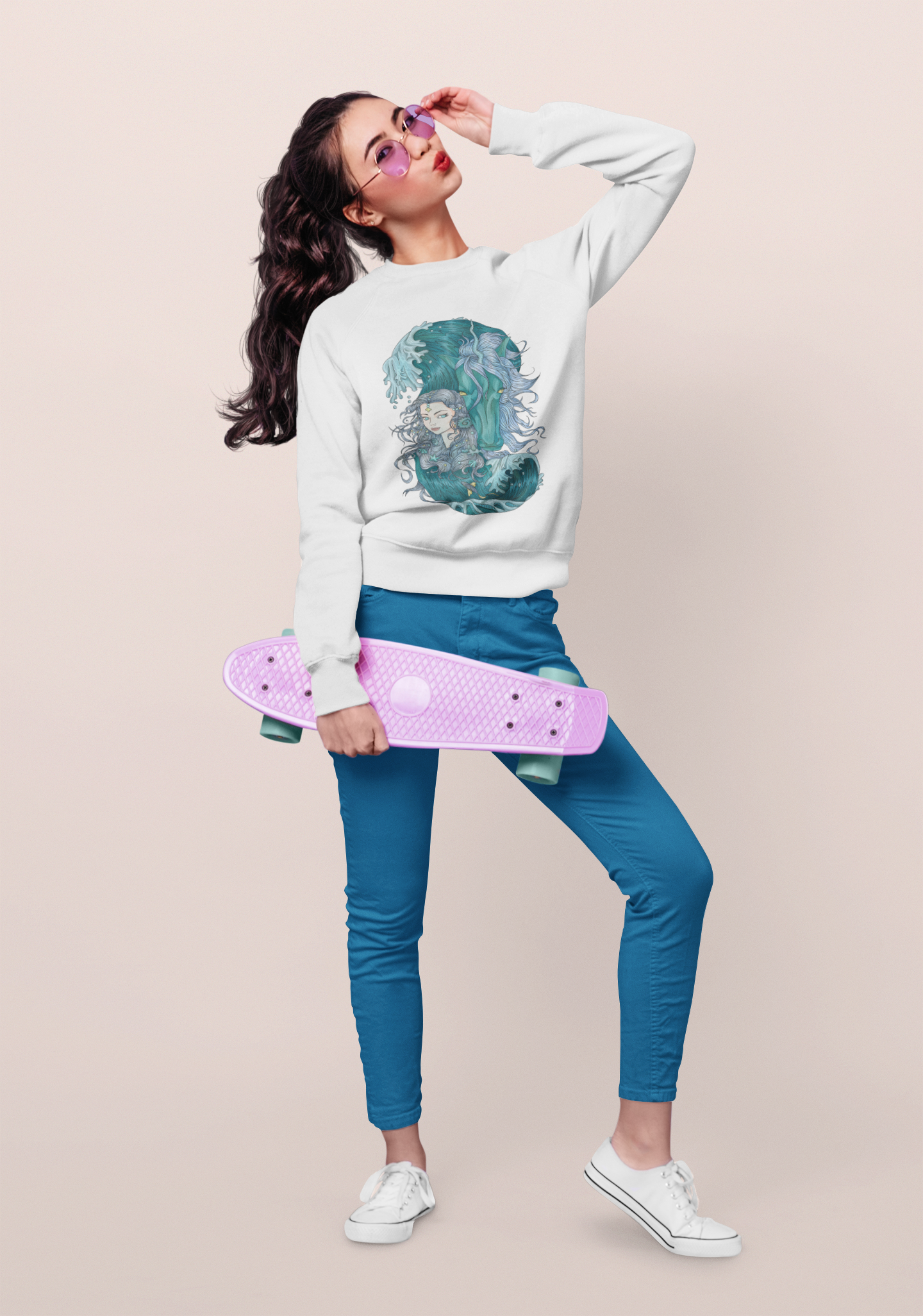 A woman wearing a white Ice Blue Princess and Magic Unicorn Sweatshirt, pink sunglasses, posing with a skateboard at a studio