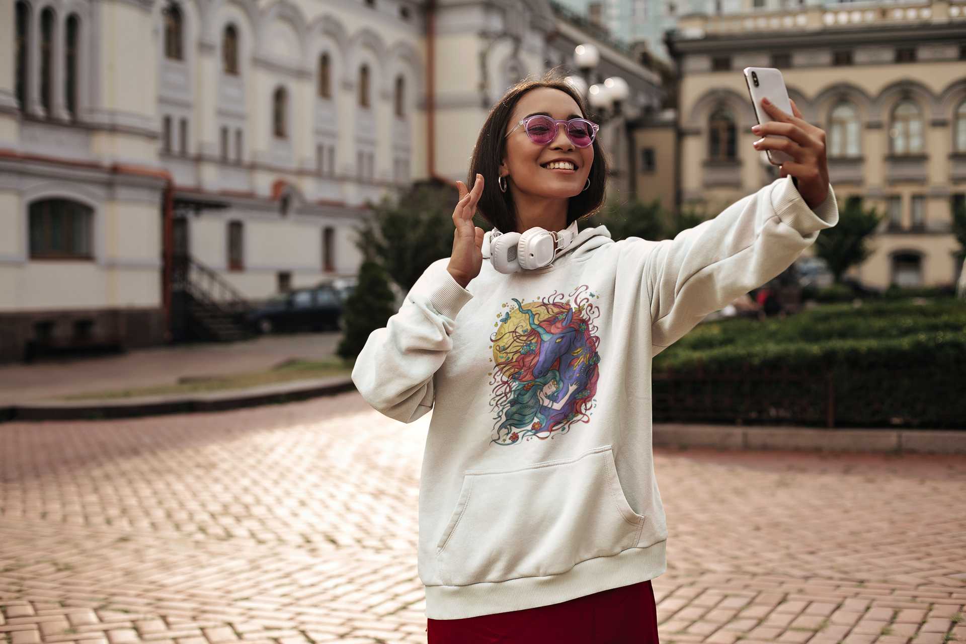 A woman with a white Cyan Princess and Magic Unicorn Hoodie taking a selfie while travelling