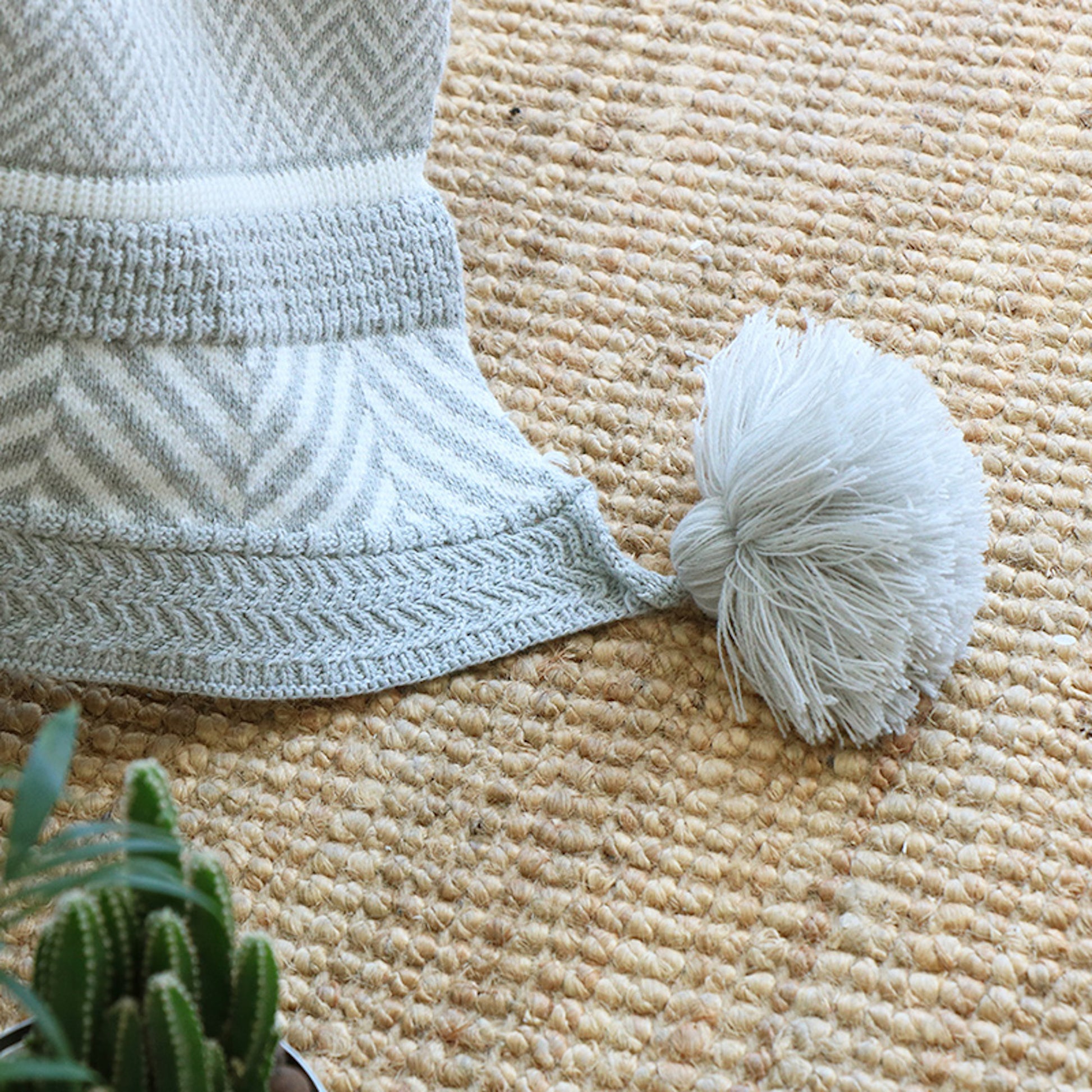 Close up shot of the pompom of the Hem Soft Bohemia Gray Knitted Throw Blanket