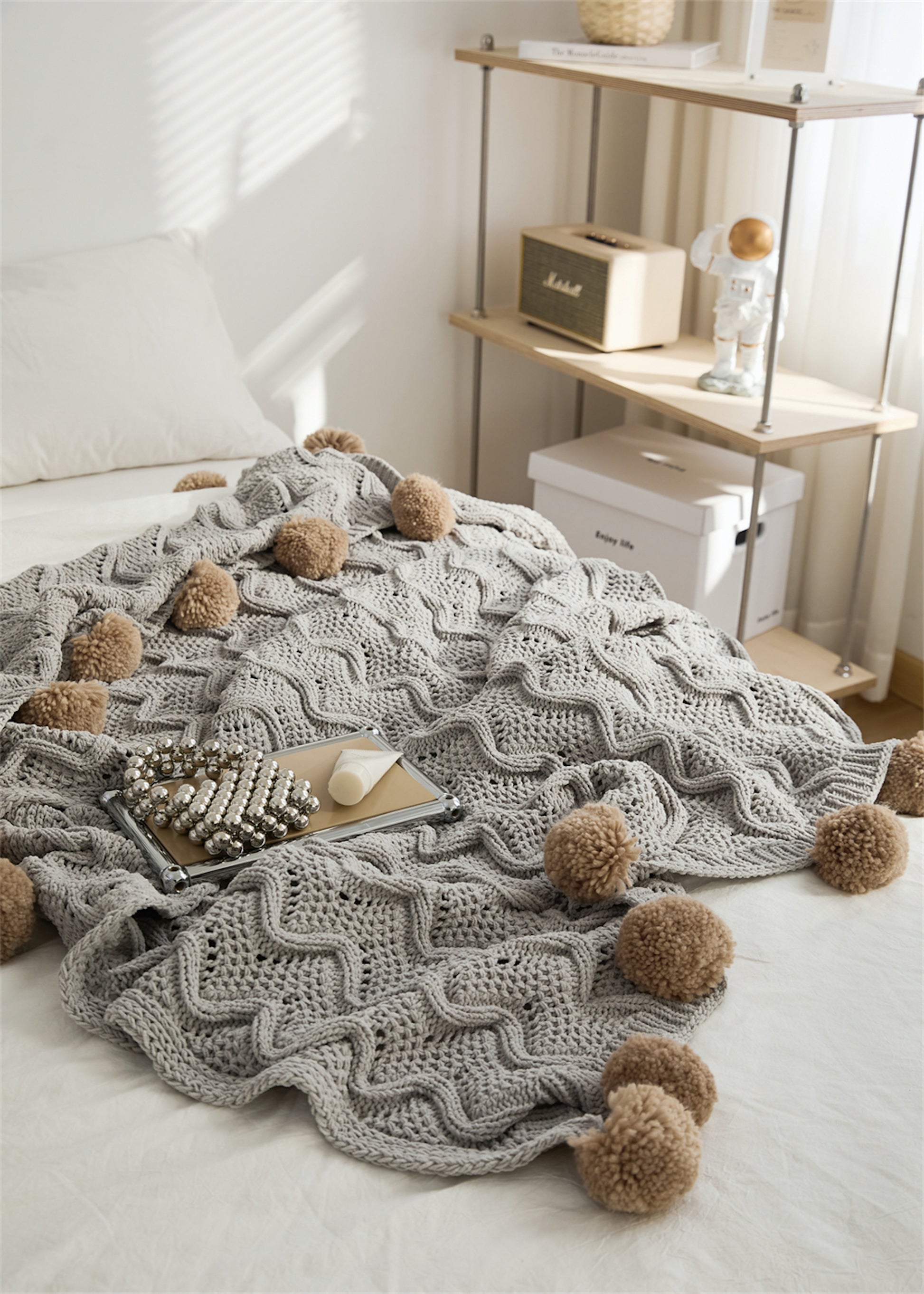 Gray Pompom Fringes Solid Chenille Knitted Throw Blanket on a bed