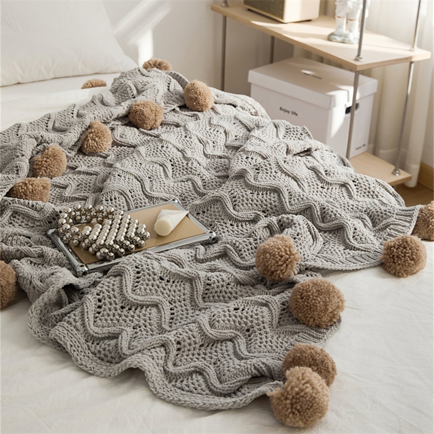 Gray Pompom Fringes Solid Chenille Knitted Throw Blanket on a bed