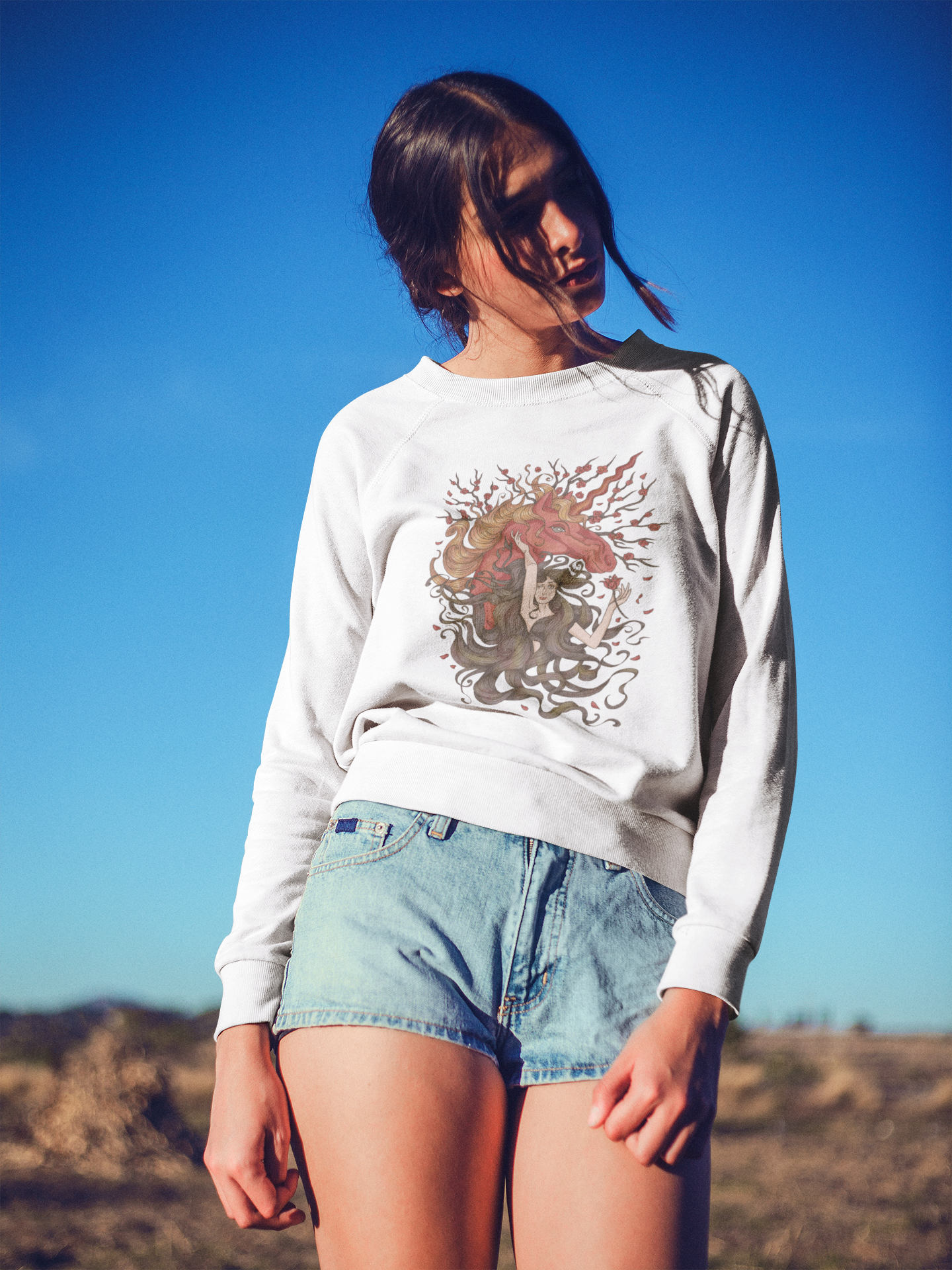 A woman wearing Walnut Brown Princess and Magic Unicorn Sweatshirt and denim short posing outdoors