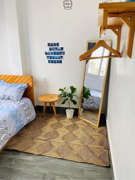 Rectangle Seagrass Rug in a bedroom corner in front of a mirror