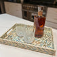 Turquoise Rectangle Flower Pattern Mother of Pearl Tray on the kitchen counter with glasses and a bottle