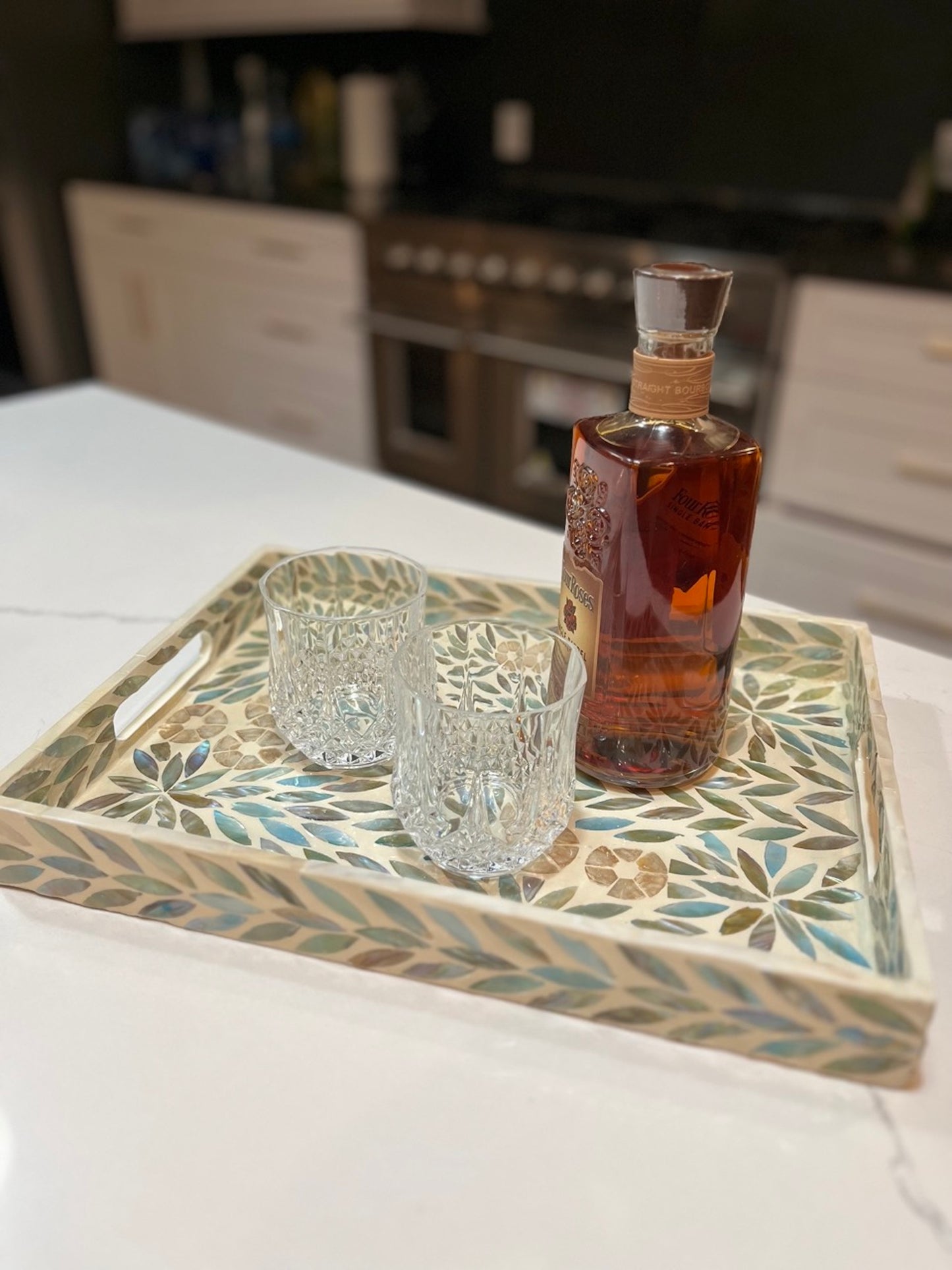 Turquoise Rectangle Flower Pattern Mother of Pearl Tray on the kitchen counter with glasses and a bottle