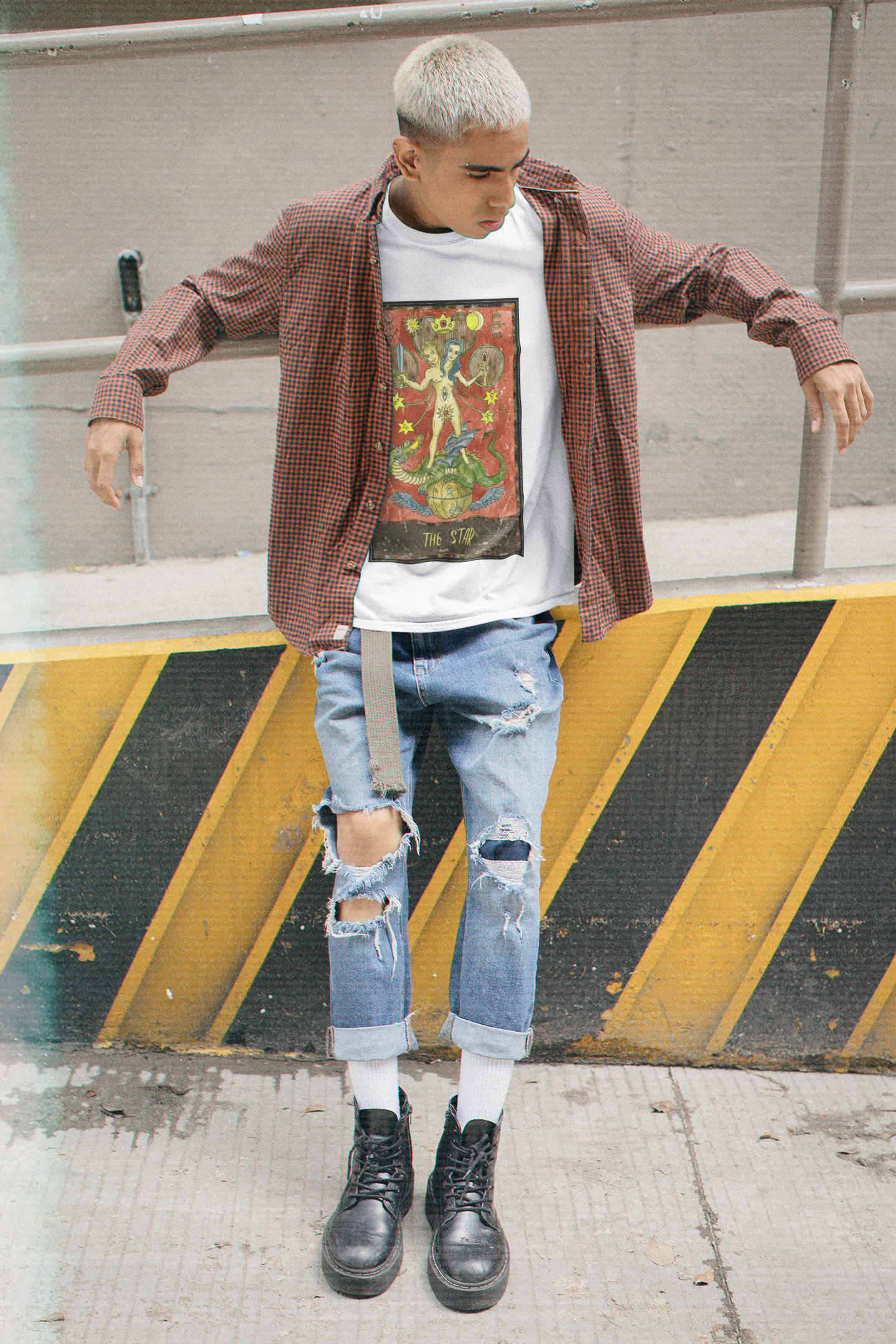 A man wearing a white The Star Tarot Card T-Shirt inside of a collar shirt, ripped blue jeans and black shoes