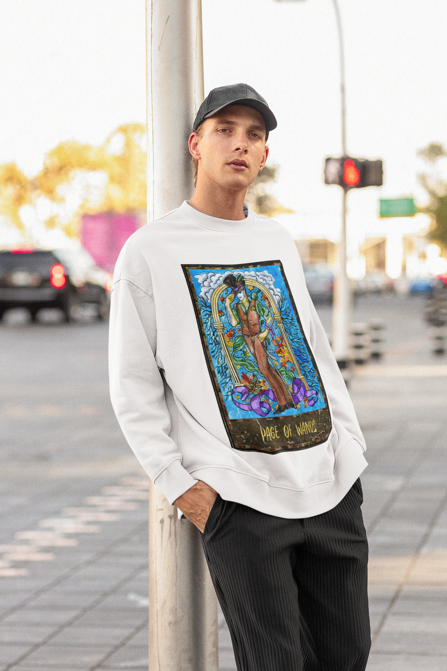 A man in a cap wearing a white Page of Wands Tarot Card Sweatshirt and black pants