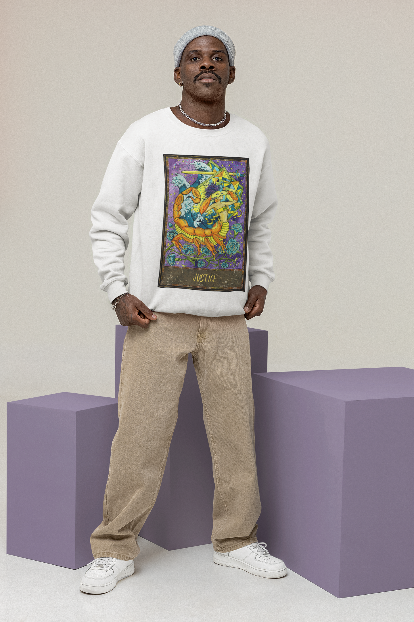 A man wearing a white Justice - Tarot Card Sweatshirt, beige pants, and white shoes