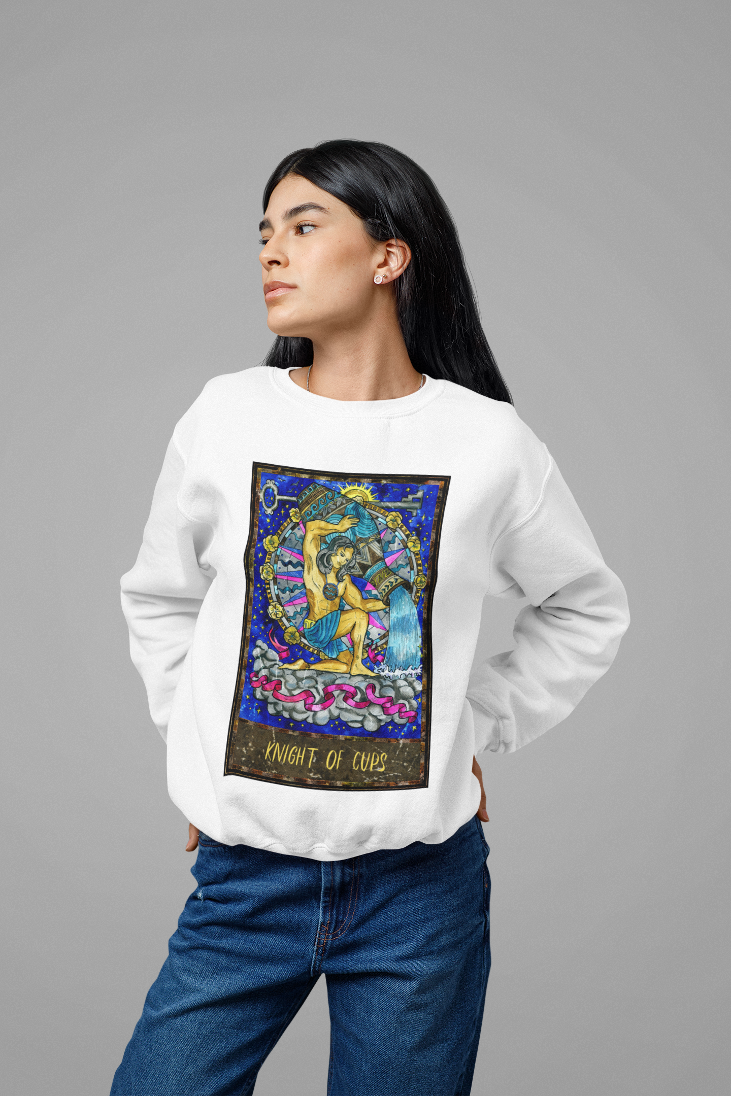 A woman wearing a white Knight of Cups Tarot Card Sweatshirt and blue jeans