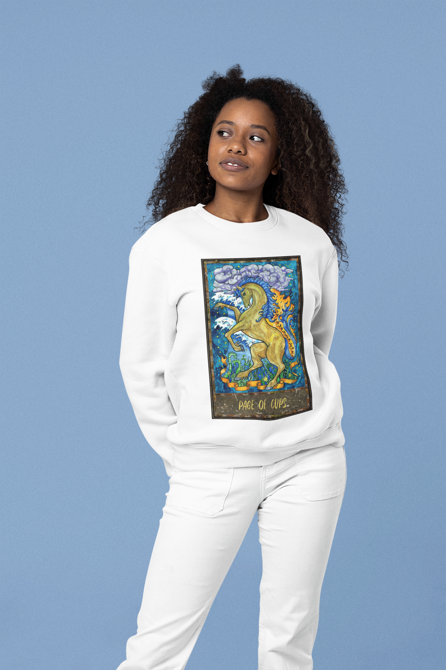 A woman wearing a white Page of Cups Tarot Card Sweatshirt, white pants