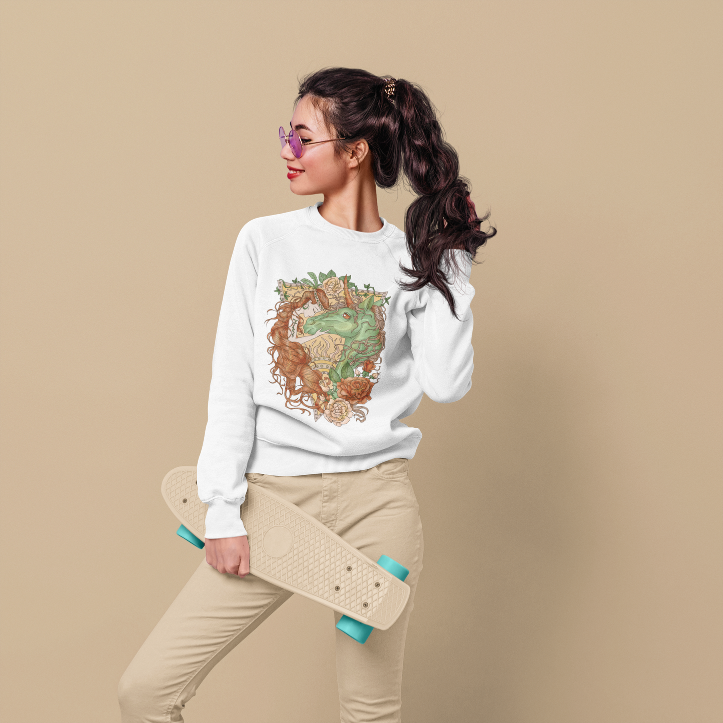 A stylish woman in sunglasses, holding a skateboard wearing a white Cocoa Brown Princess and Magic Unicorn Sweatshirt, and beige pants