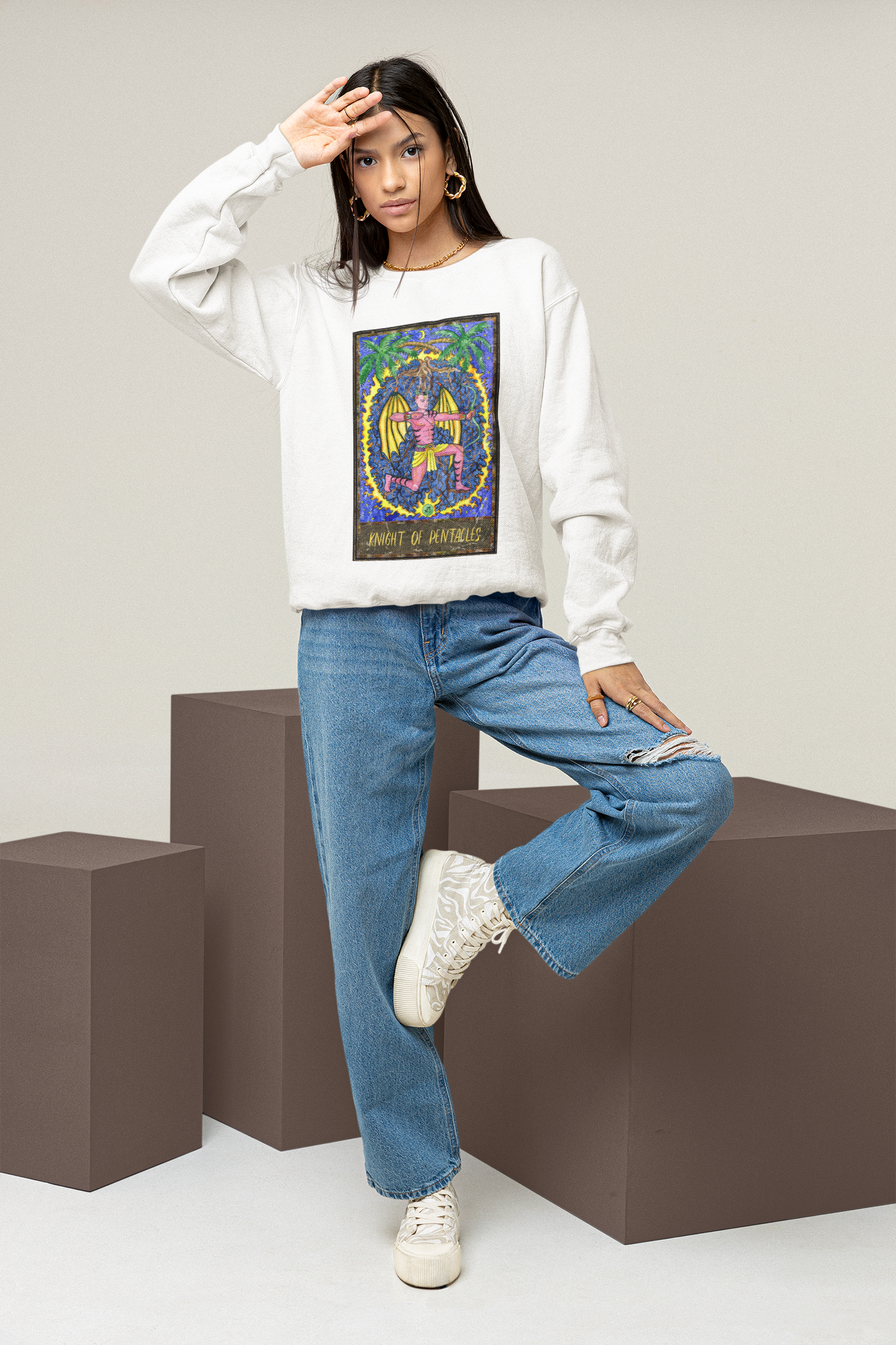 A woman wearing a white Knight of Pentacles Tarot Card Sweatshirt, blue jeans and white shoes