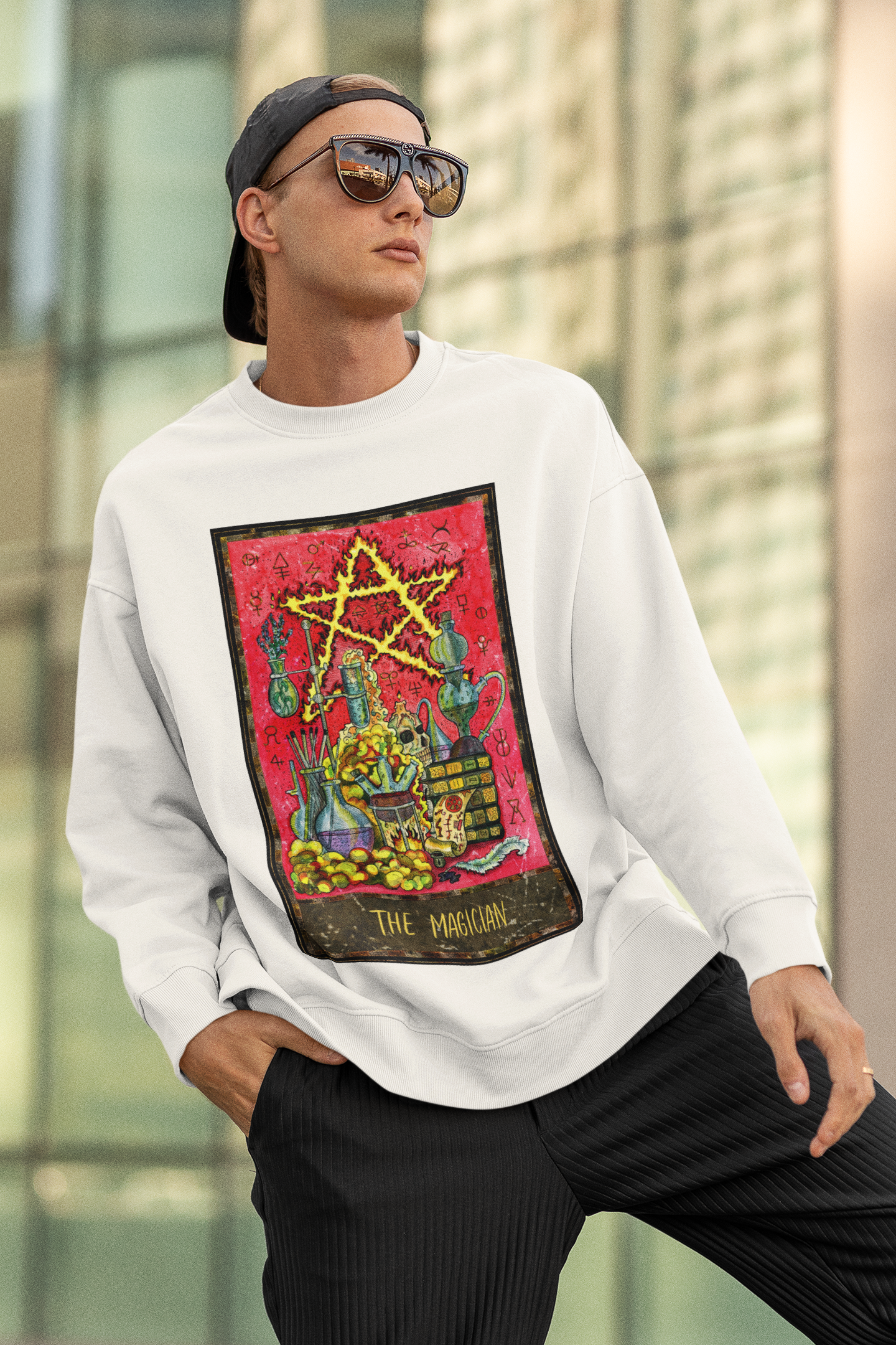 A man with sunglasses wearing a white The Magician Tarot Card Sweatshirt and black pants