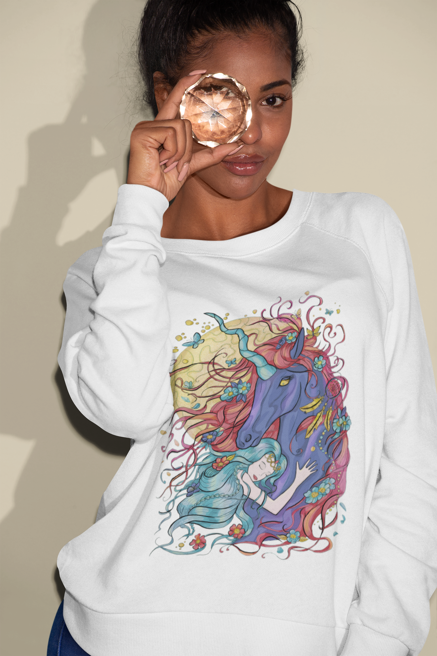 A woman looking through a gem wearing a white Cyan Princess and Magic Unicorn Sweatshirt