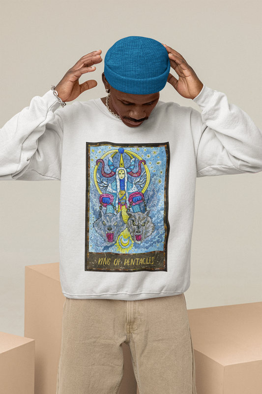 A man posing with his hands in his head wearing a blue beanie, white King of Pentacles Tarot Card Sweatshirt, and beige jeans 