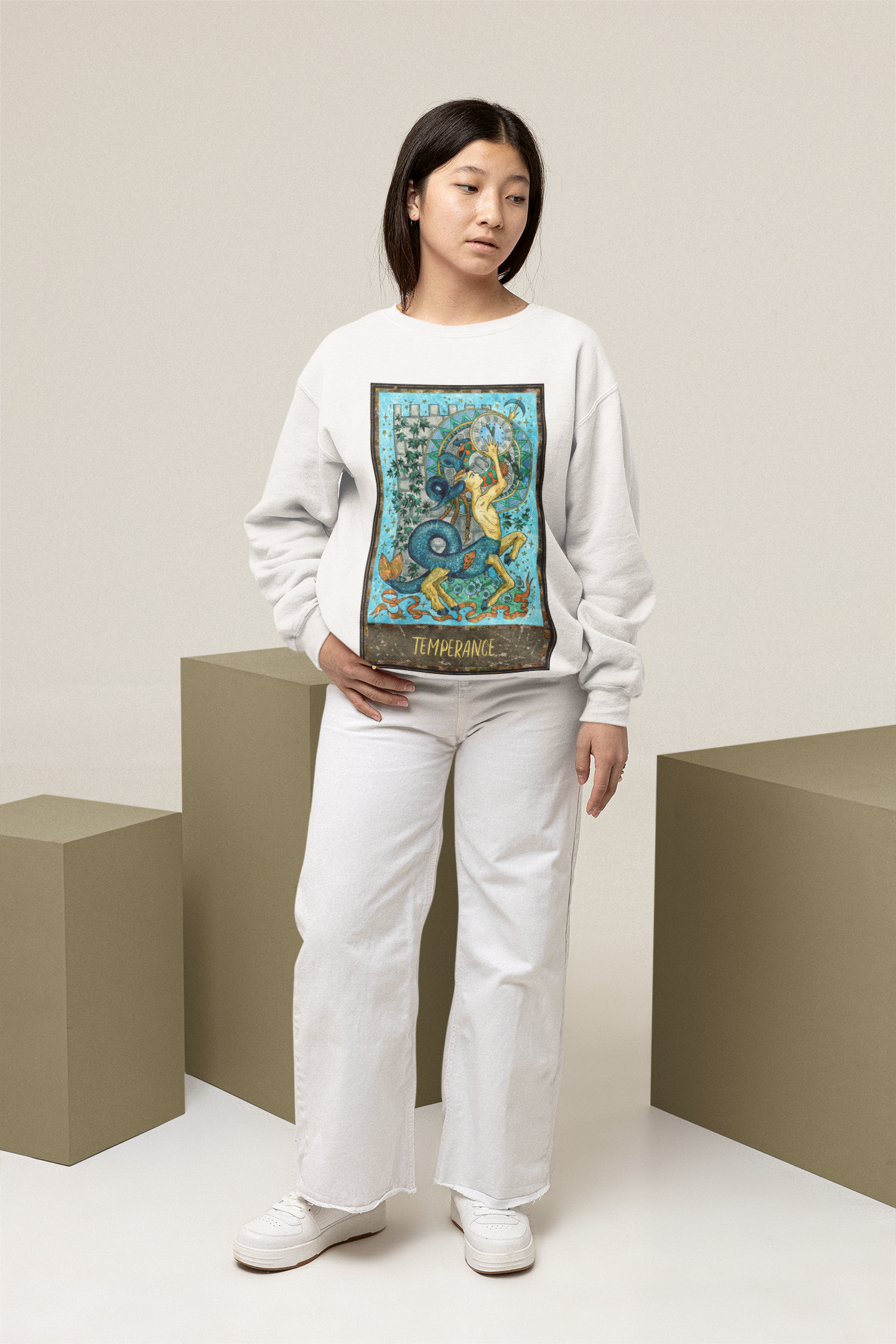 A woman wearing a white Temperance Tarot Card Sweatshirt, white pants and white shoes