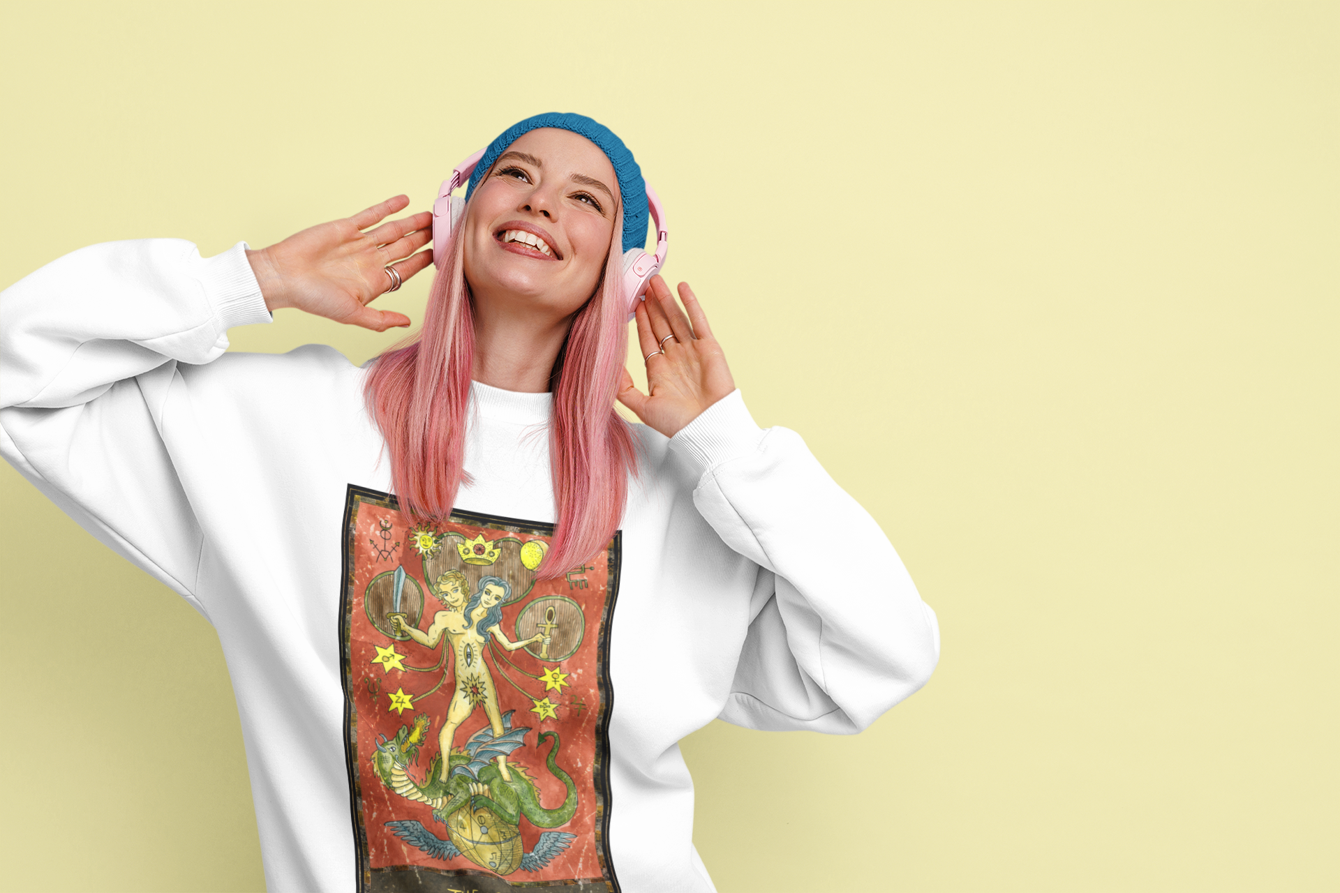 A pink hair woman with a blue beanie and headphones wearing a white The Star Tarot Card Sweatshirt