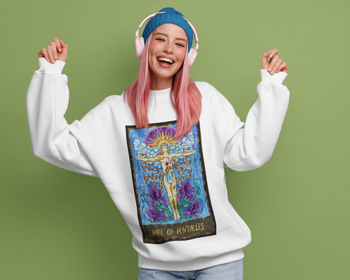 A woman with pink hair and headphone dancing wearing a white Page of Pentacles Tarot Card Sweatshirt and blue jeans