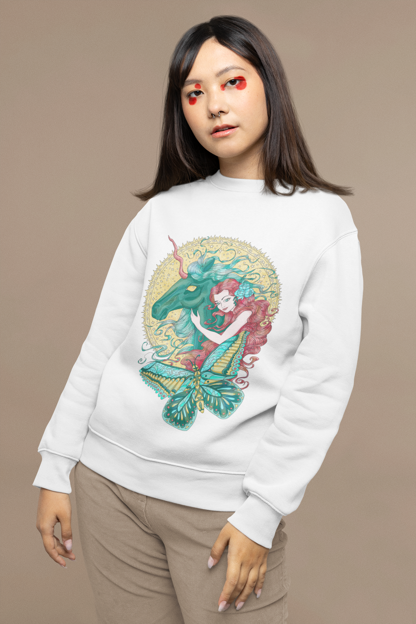 A young woman wearing a white Poppy Red Princess and Magic Unicorn Sweatshirt and beige pants