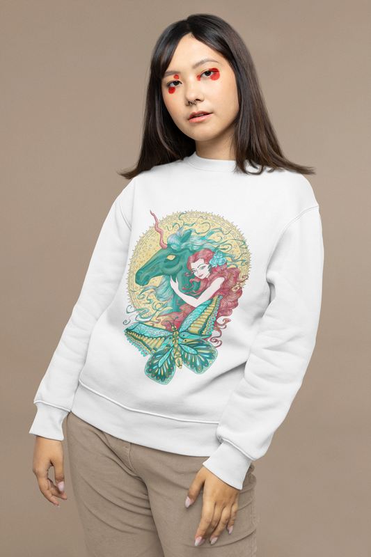 A young woman wearing a white Poppy Red Princess and Magic Unicorn Sweatshirt and beige pants