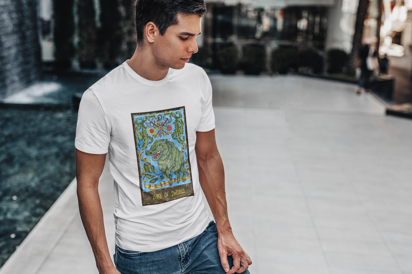 A man wearing a white Page of Swords Tarot Card T-shirt and blue jeans