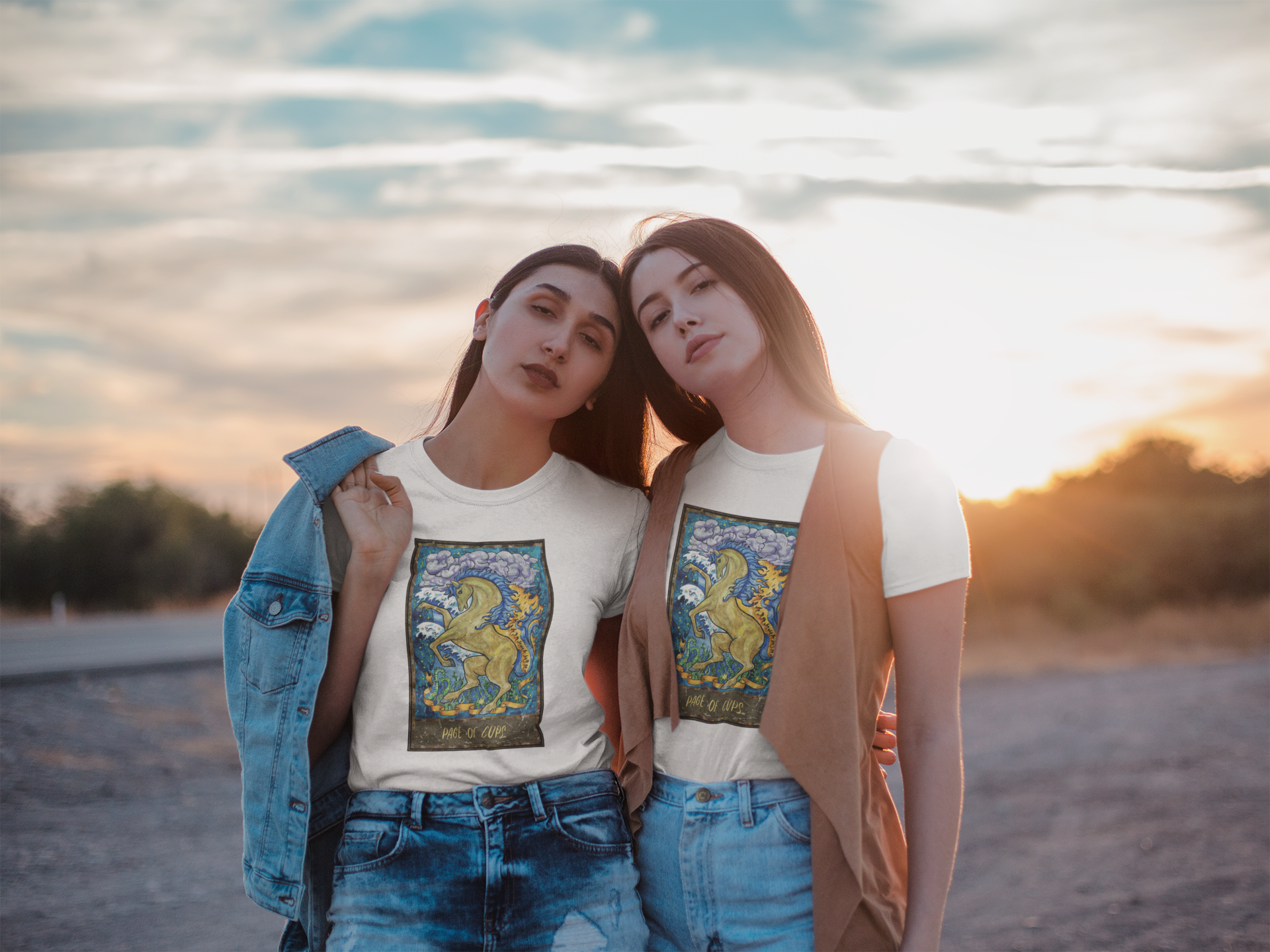 Two pretty girls posing in white Page of Cups Tarot Card T-shirts and denim shorts