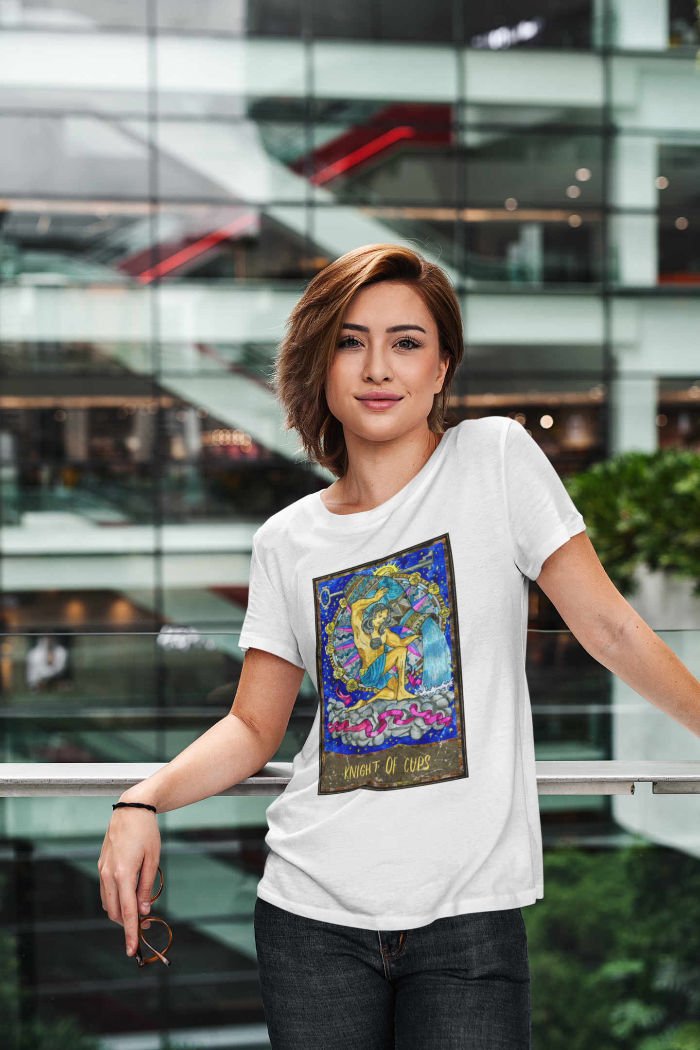 A woman wearing a white Knight of Cups Tarot Card T-shirt and dark blue jeans