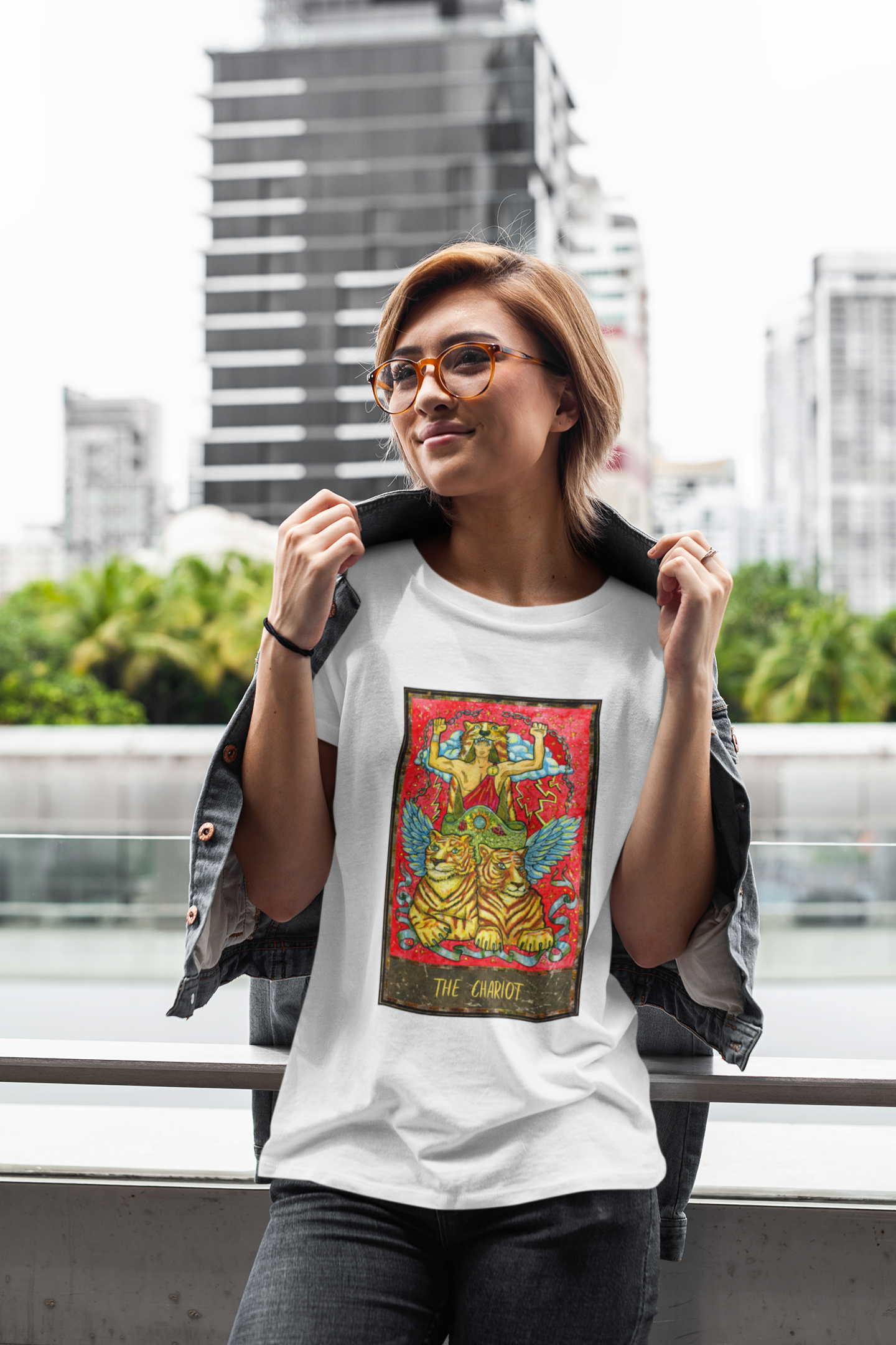 A woman posing wearing a white The Chariot Tarot Card T-shirt and jeans