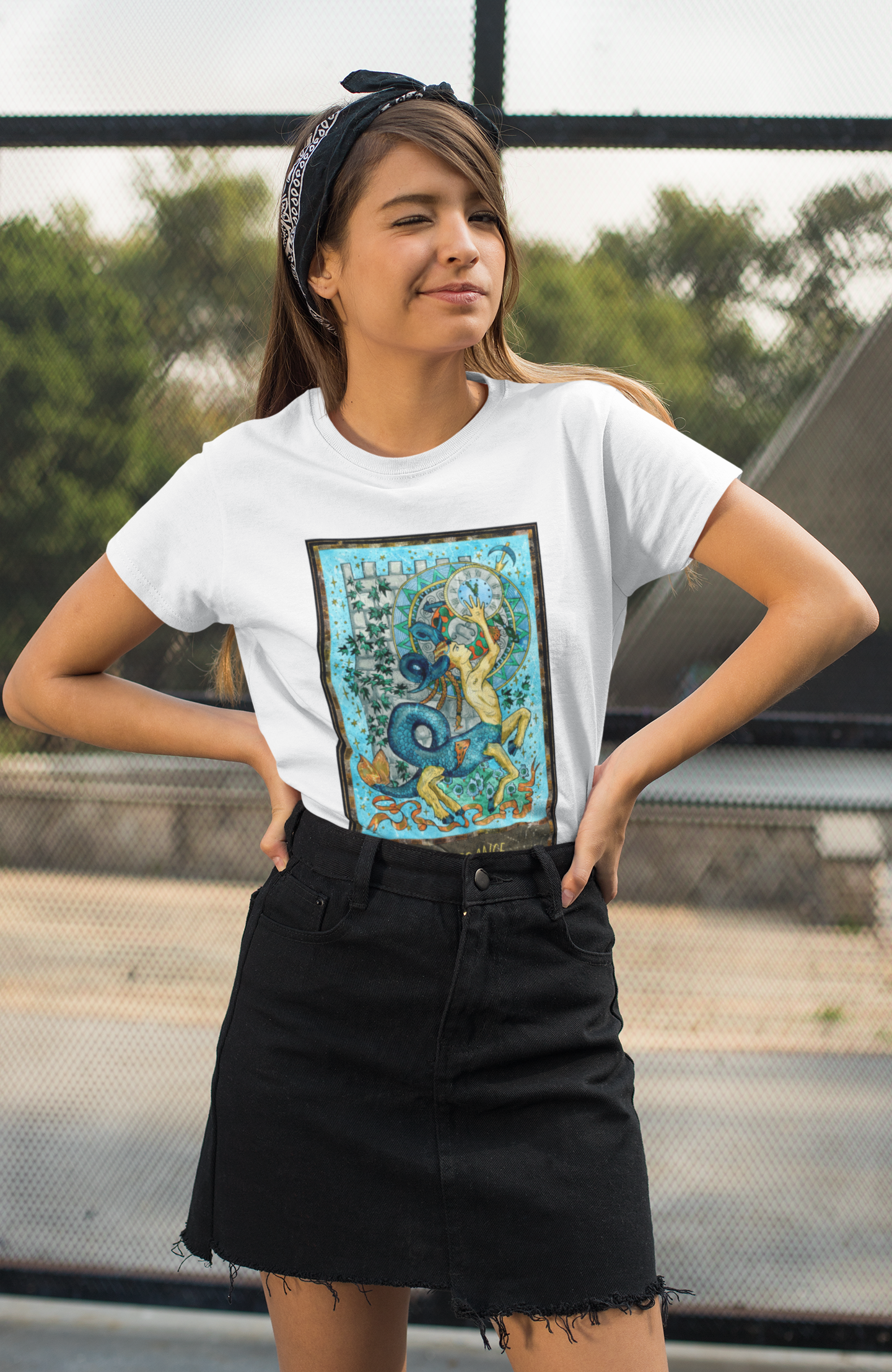 A woman with headband winking at the camera wearing a white Temperance Tarot Card T-shirt and black skirt