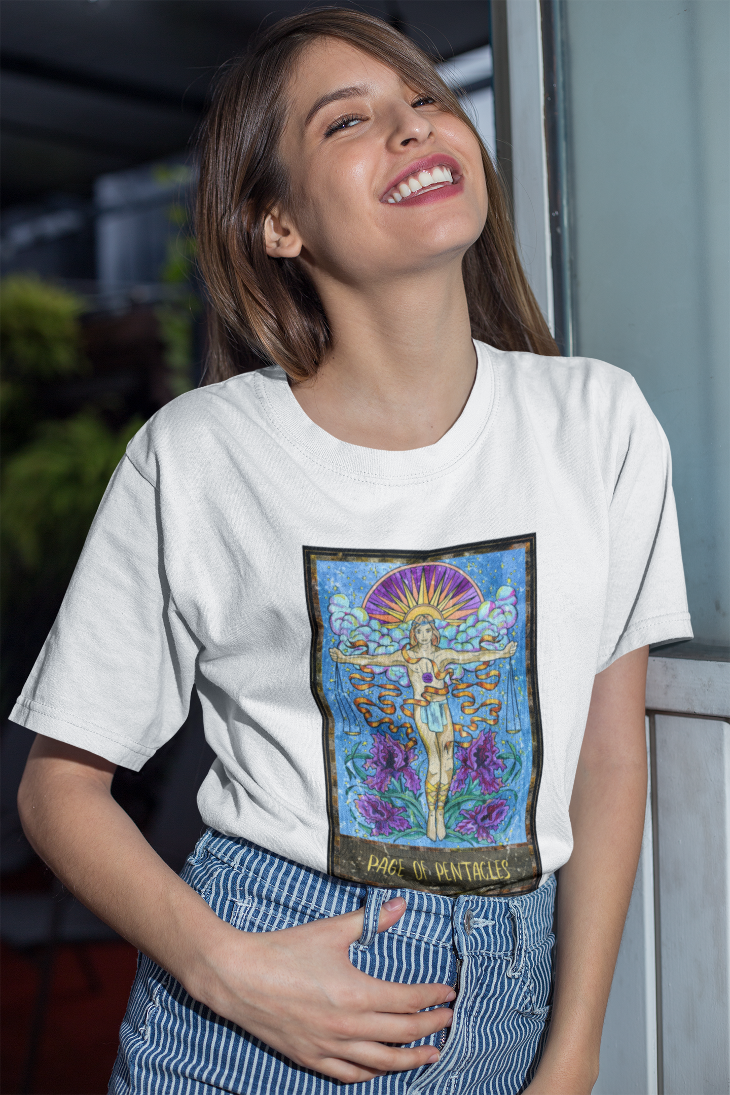 A woman wearing a white Page of Pentacles Tarot Card T-shirt and stripe pants